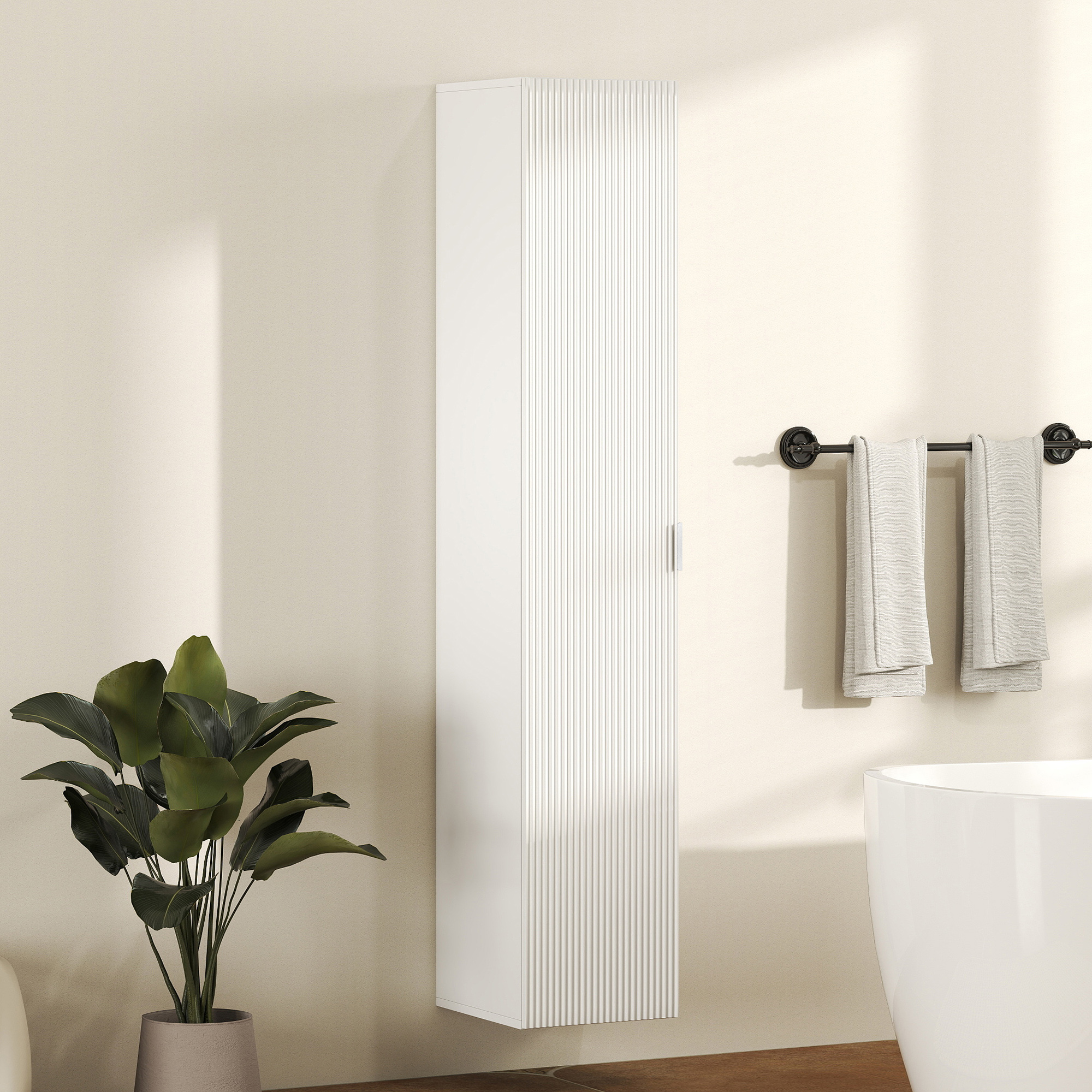 Un mobile bianco da parete con scanalature verticali, accanto a una pianta e una vasca.