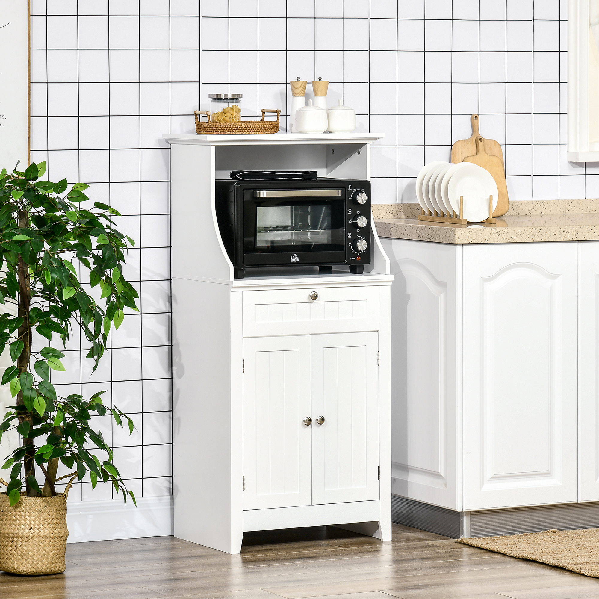 Mobiletto da cucina bianco con mini forno nero e pianta verde.