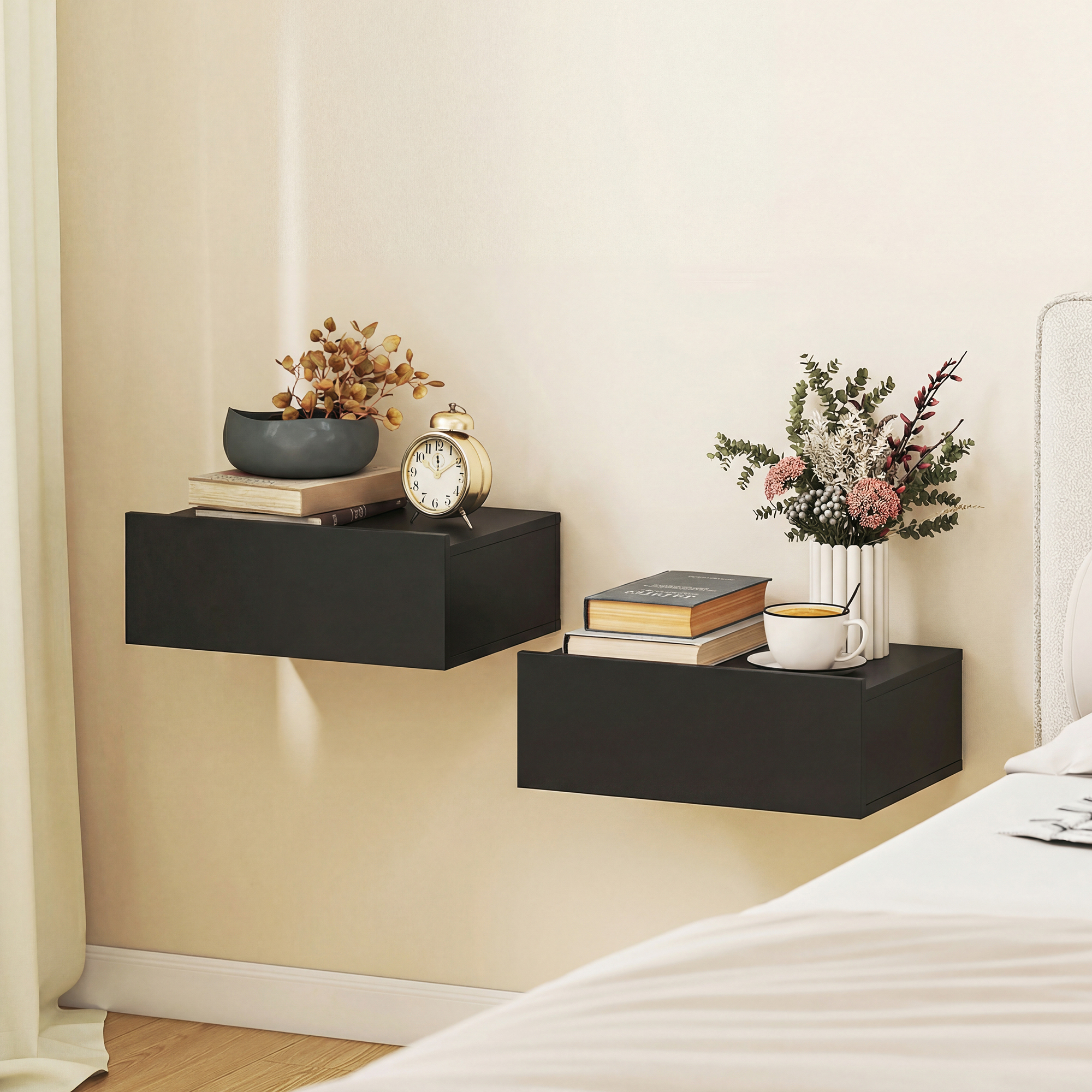 Due mensole flottanti nere con decorazioni: libri, sveglia, vaso con fiori secchi e tazza da caffè.