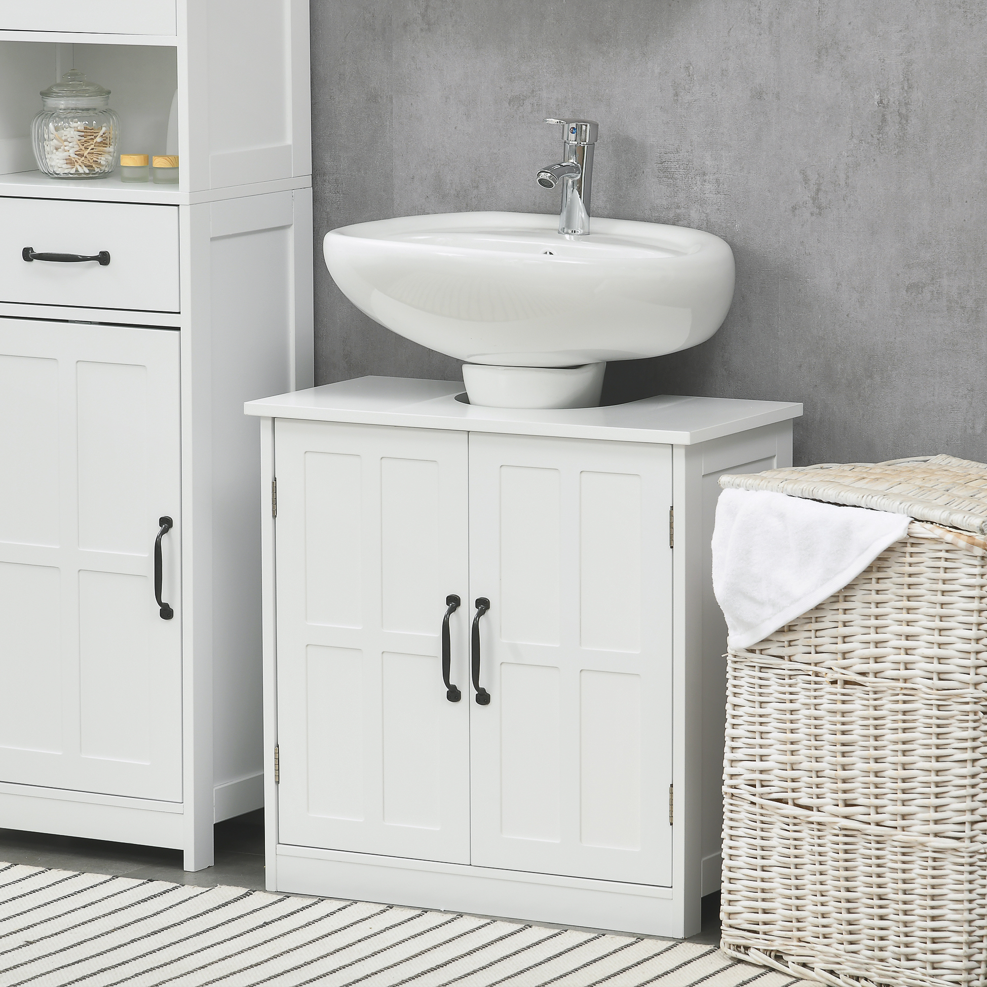 Un set di mobili da bagno bianchi con lavandino, armadi e cesto della biancheria.