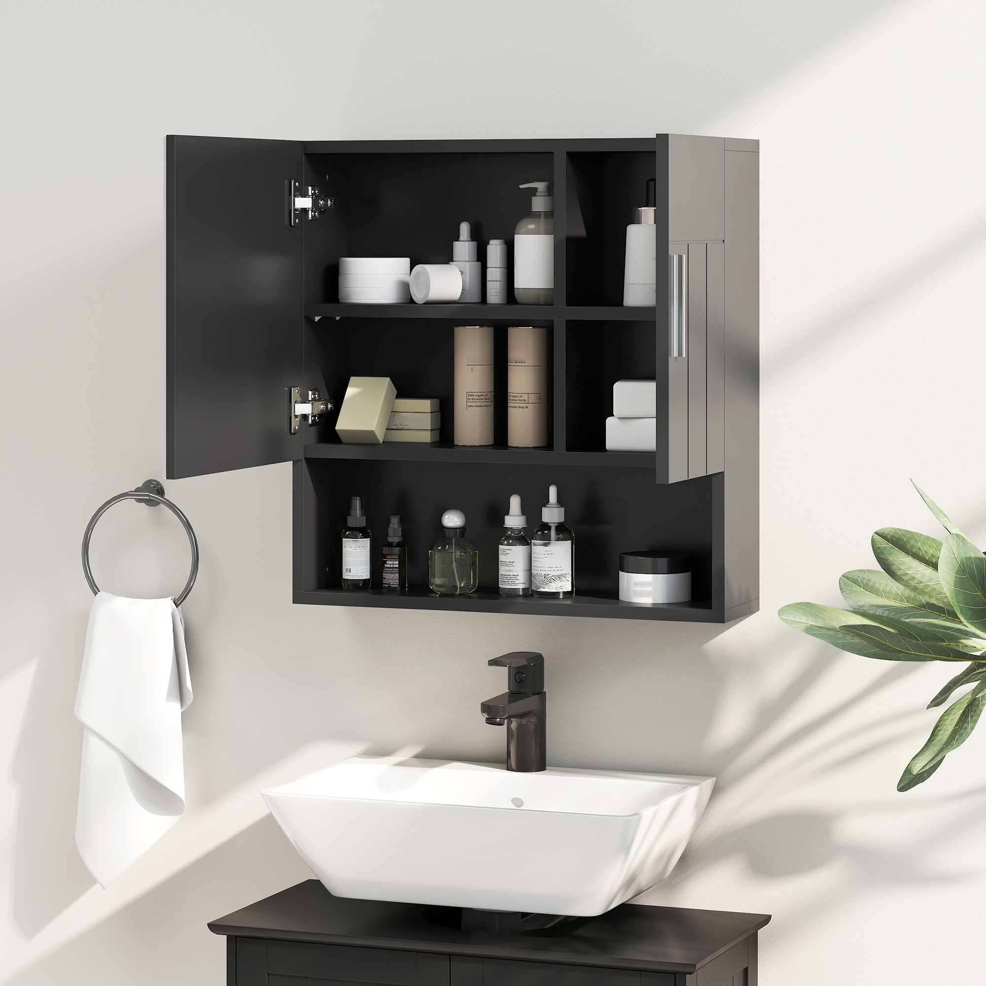Un mobiletto da bagno nero sopra un lavandino con rubinetto. Portasciugamani con asciugamano bianco.