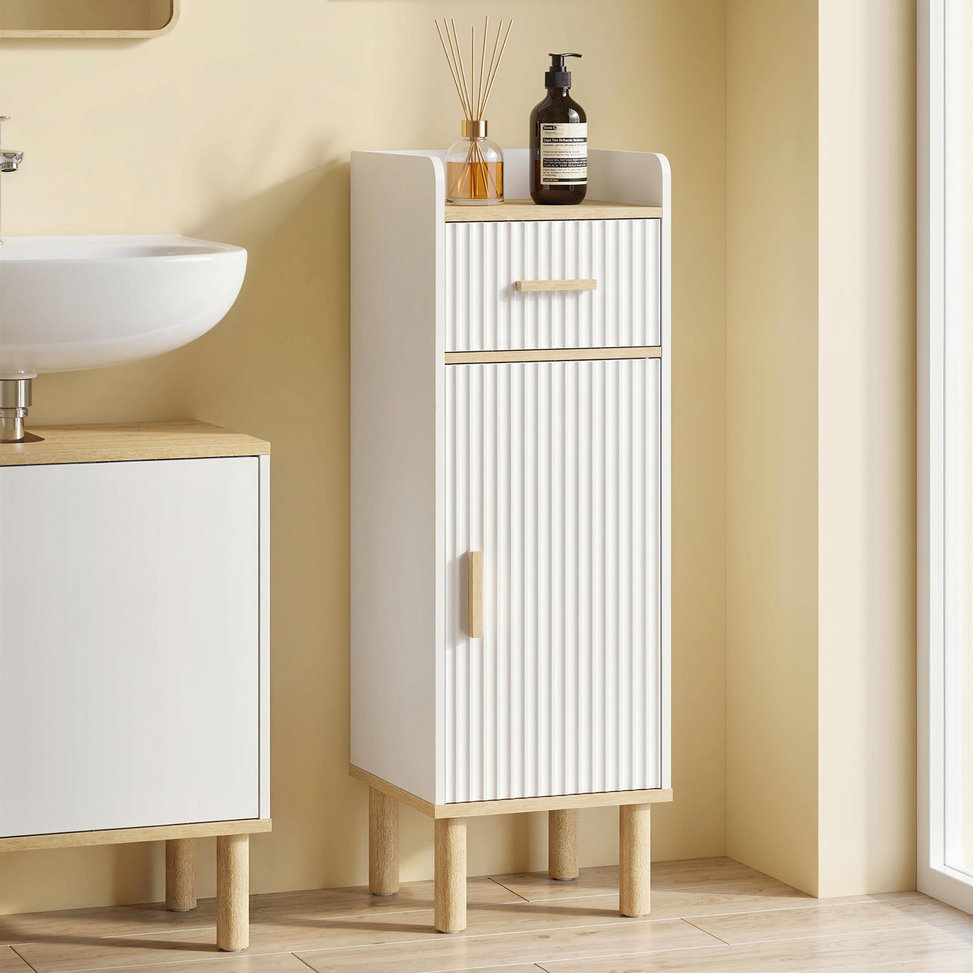 Un mobile da bagno bianco con accenti in legno e un lavandino vicino.