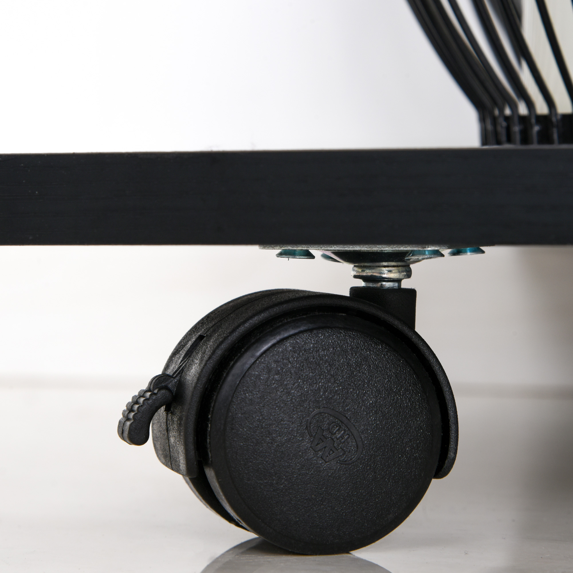 Primo piano di una ruota piroettante nera fissata a un telaio metallico nero.