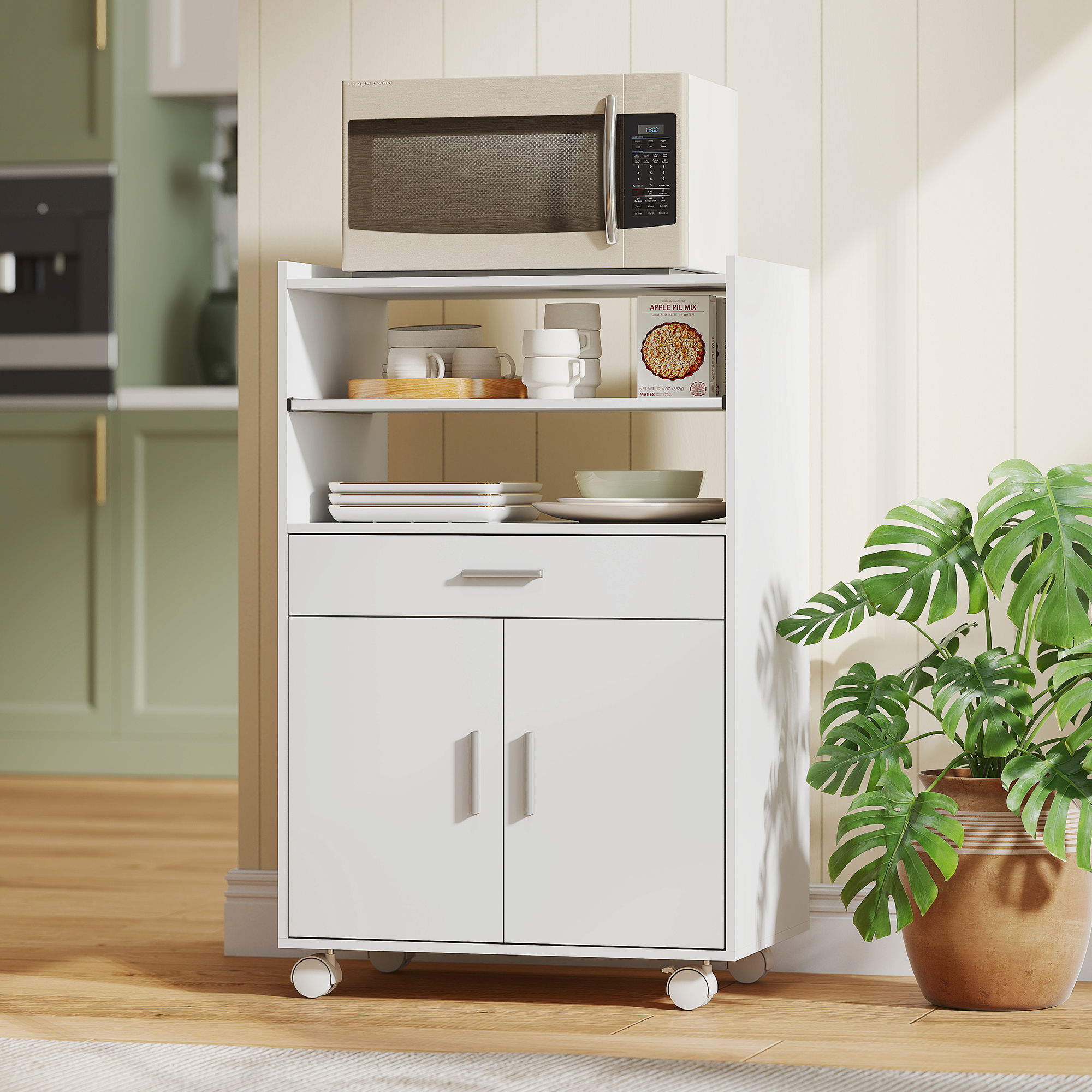 Carrello da cucina bianco con microonde, piatti e una pianta in vaso accanto.