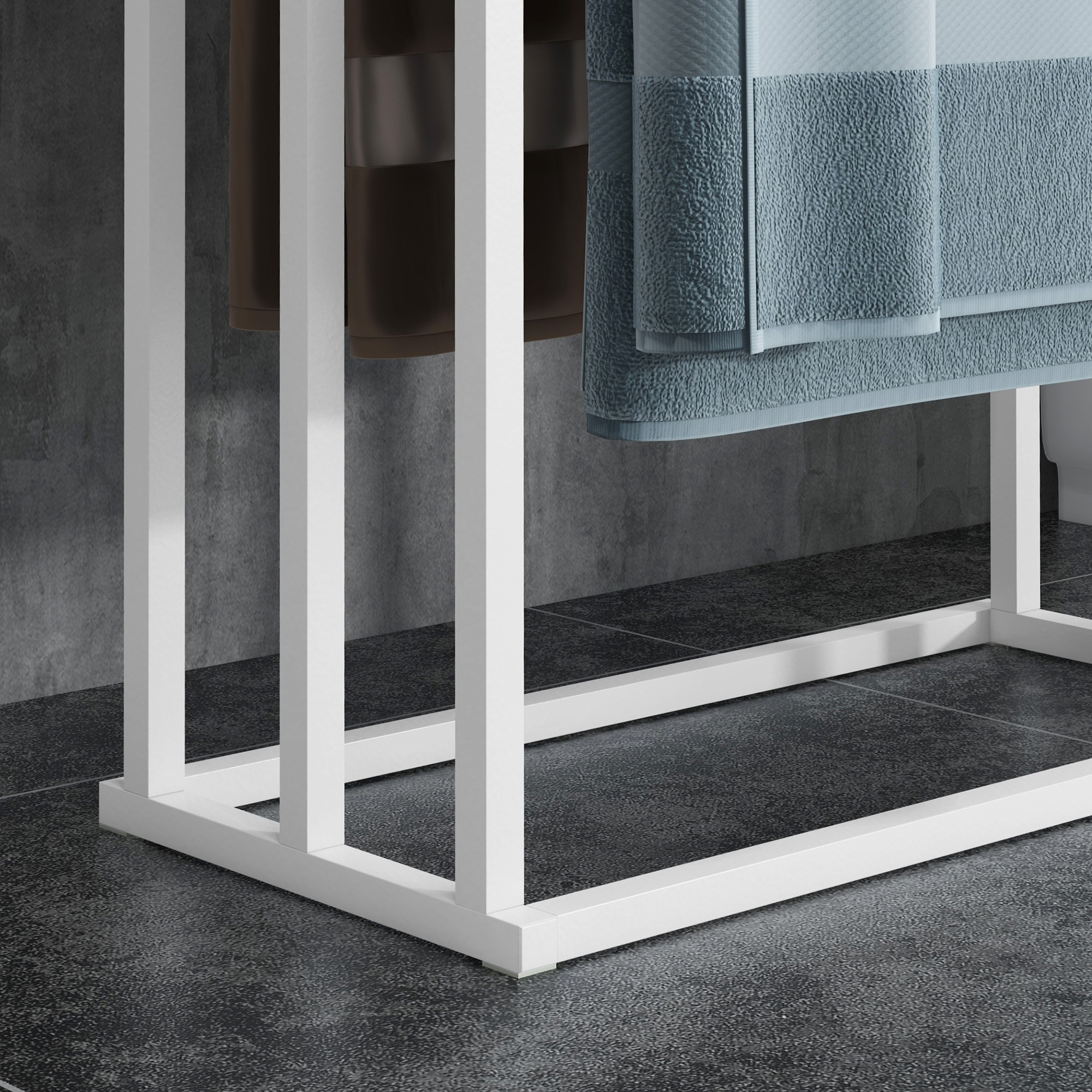 Un porta asciugamani bianco con asciugamani marroni e blu contro un muro grigio.