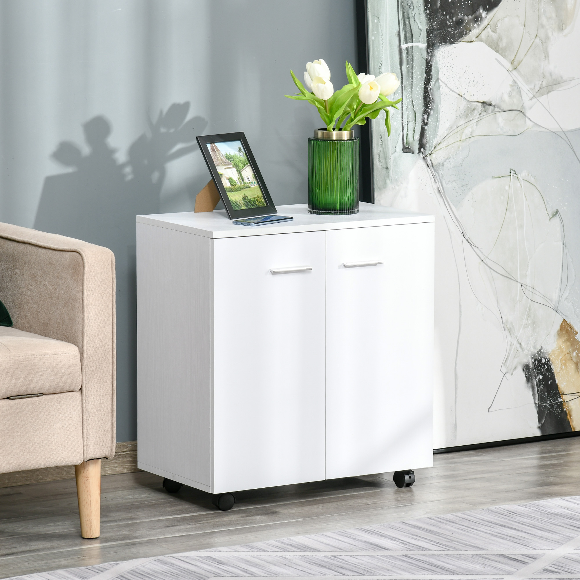 Un mobile bianco su ruote con un vaso di tulipani bianchi e una cornice.