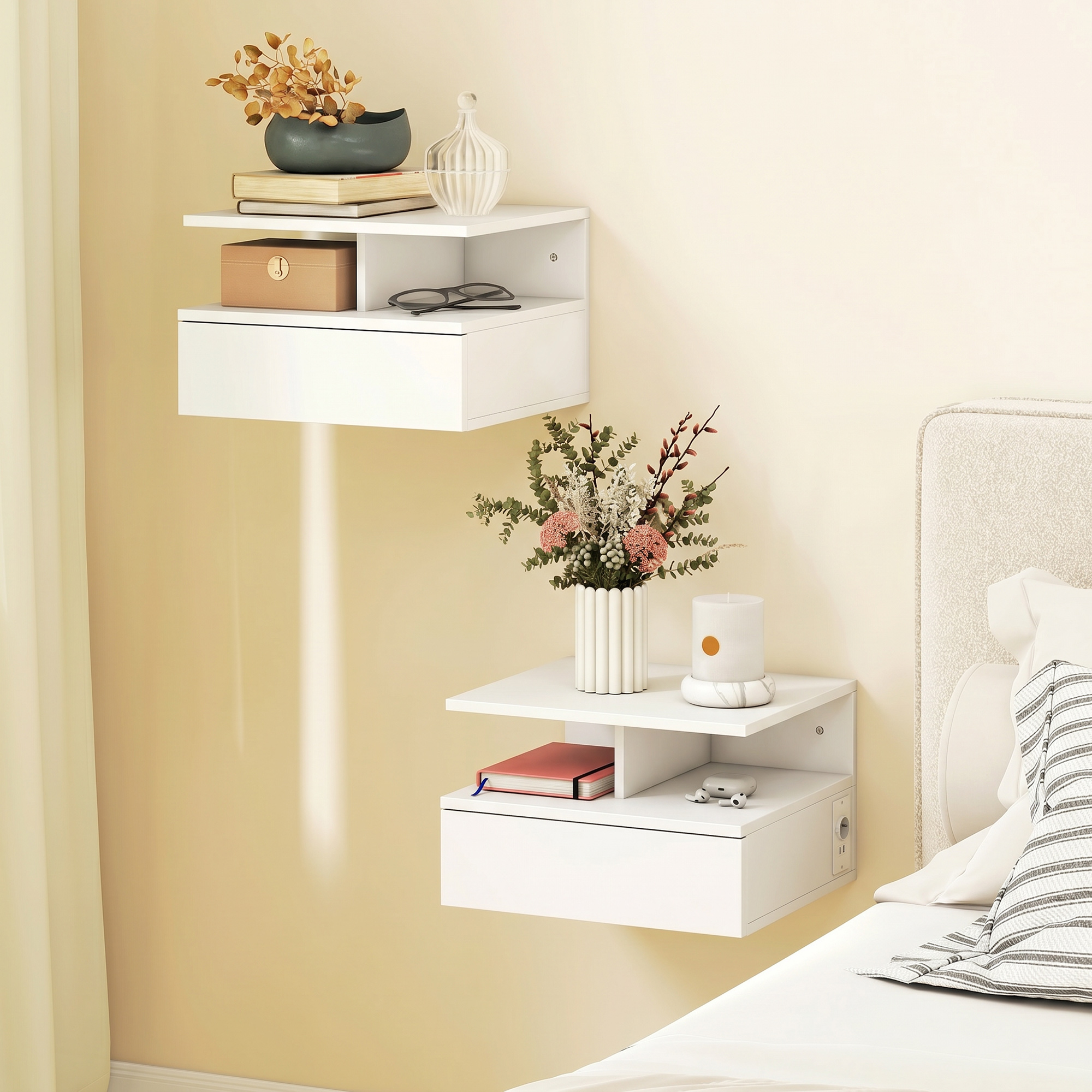 Due mensole bianche a muro con decorazioni, libri e una lampada accanto a un letto.