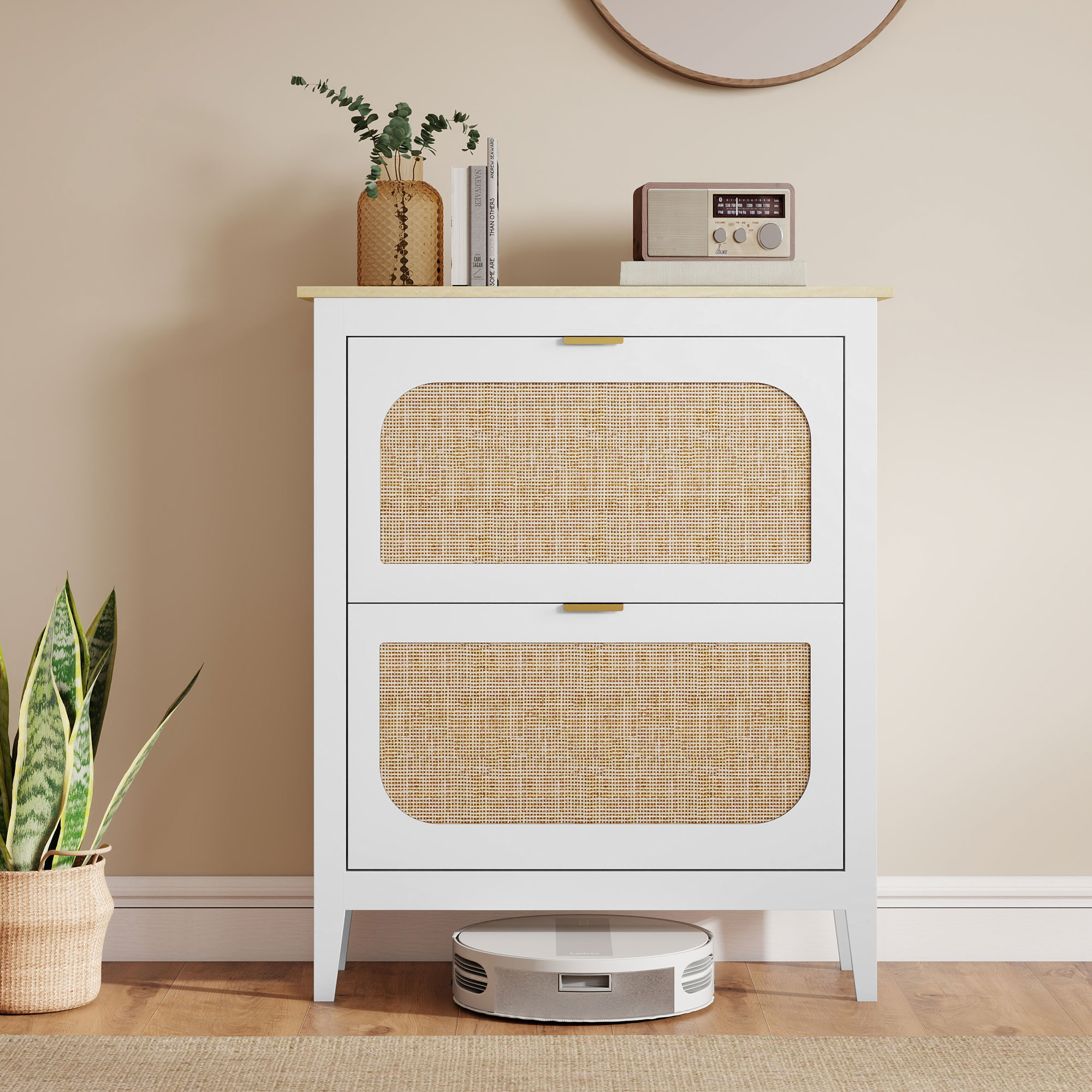 Un mobile bianco con ante in rattan, decorato con vaso, libri e radio.