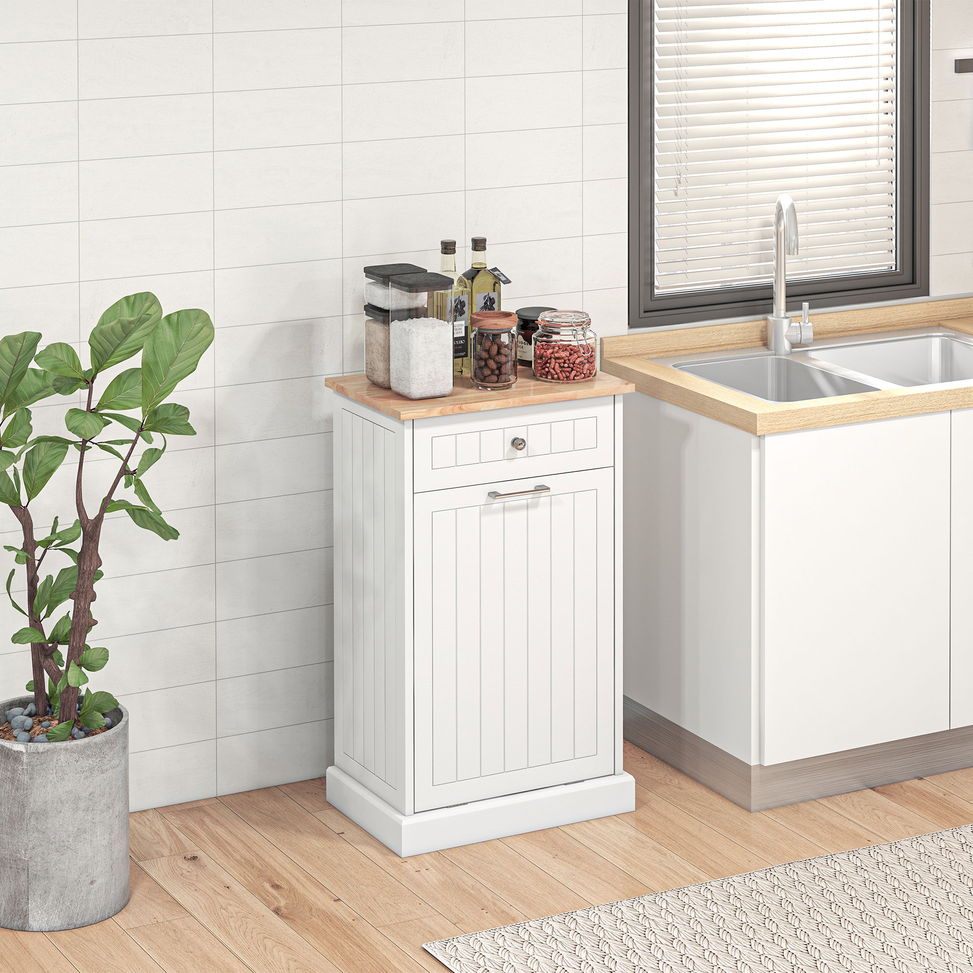 Mobili da cucina bianchi con piano di lavoro in legno, lavello, pianta e credenza.