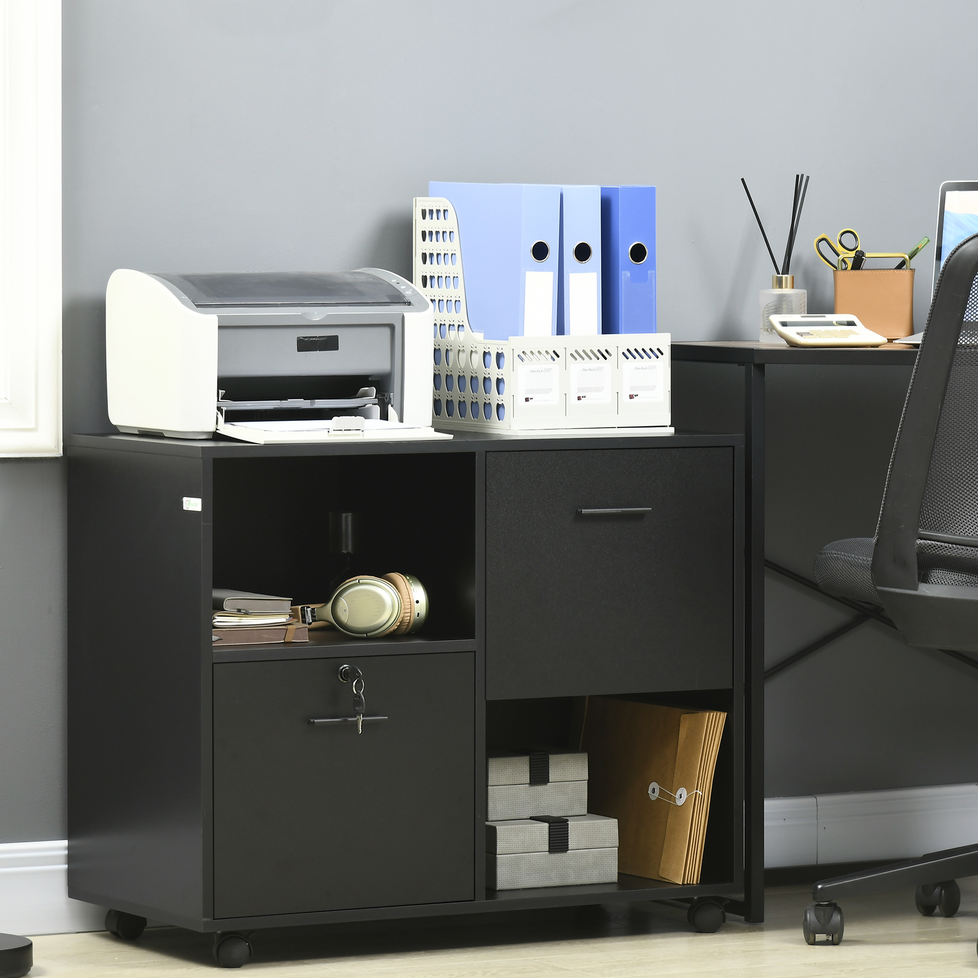 Mobile archivio nero con stampante, cuffie, cartelle, scatole e forniture per ufficio.