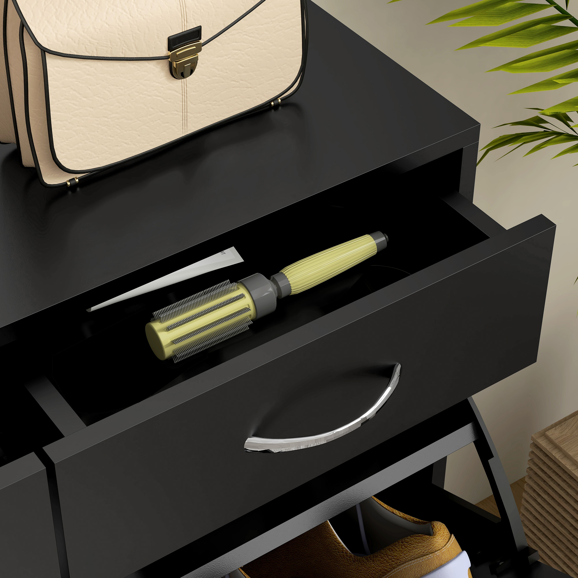 Una borsa beige è sopra un comò nero con un cassetto aperto contenente una spazzola per capelli.