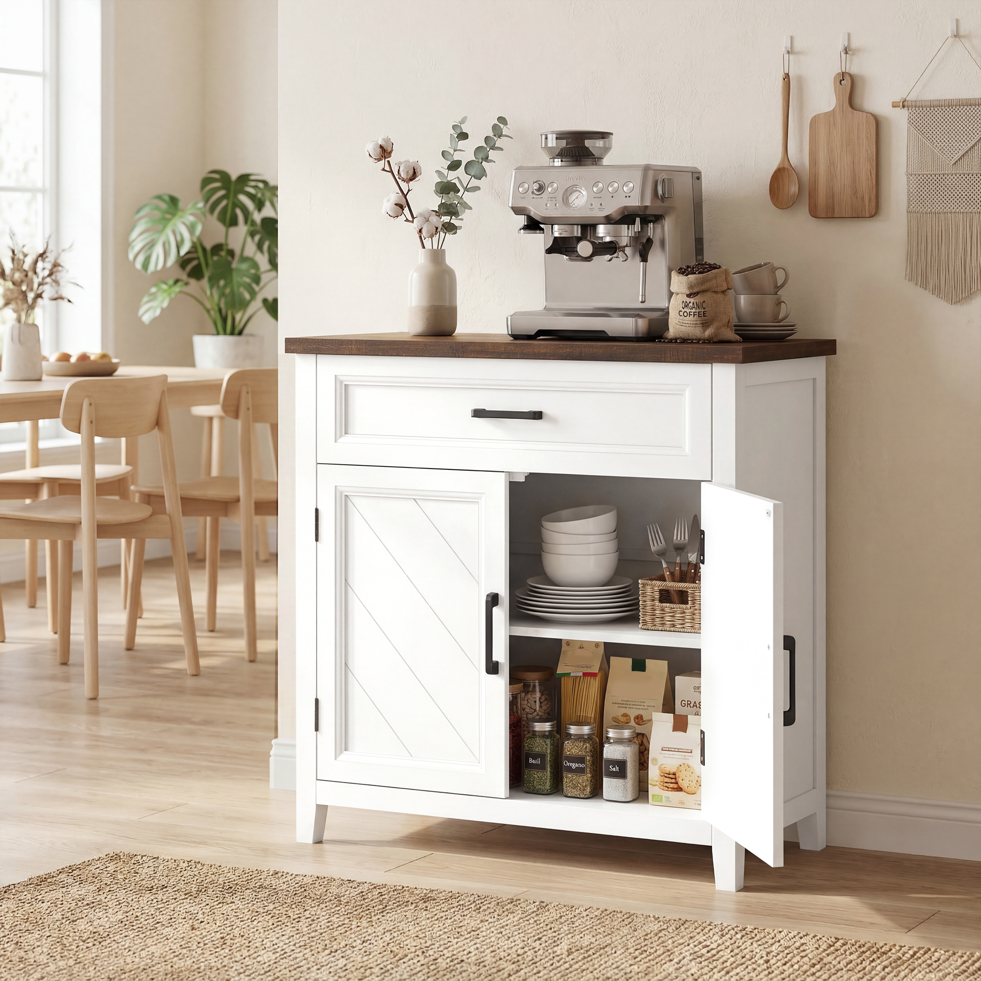 Macchina per espresso argentata su un mobile bianco con piano in legno. Accanto, un vaso con fiori di cotone.