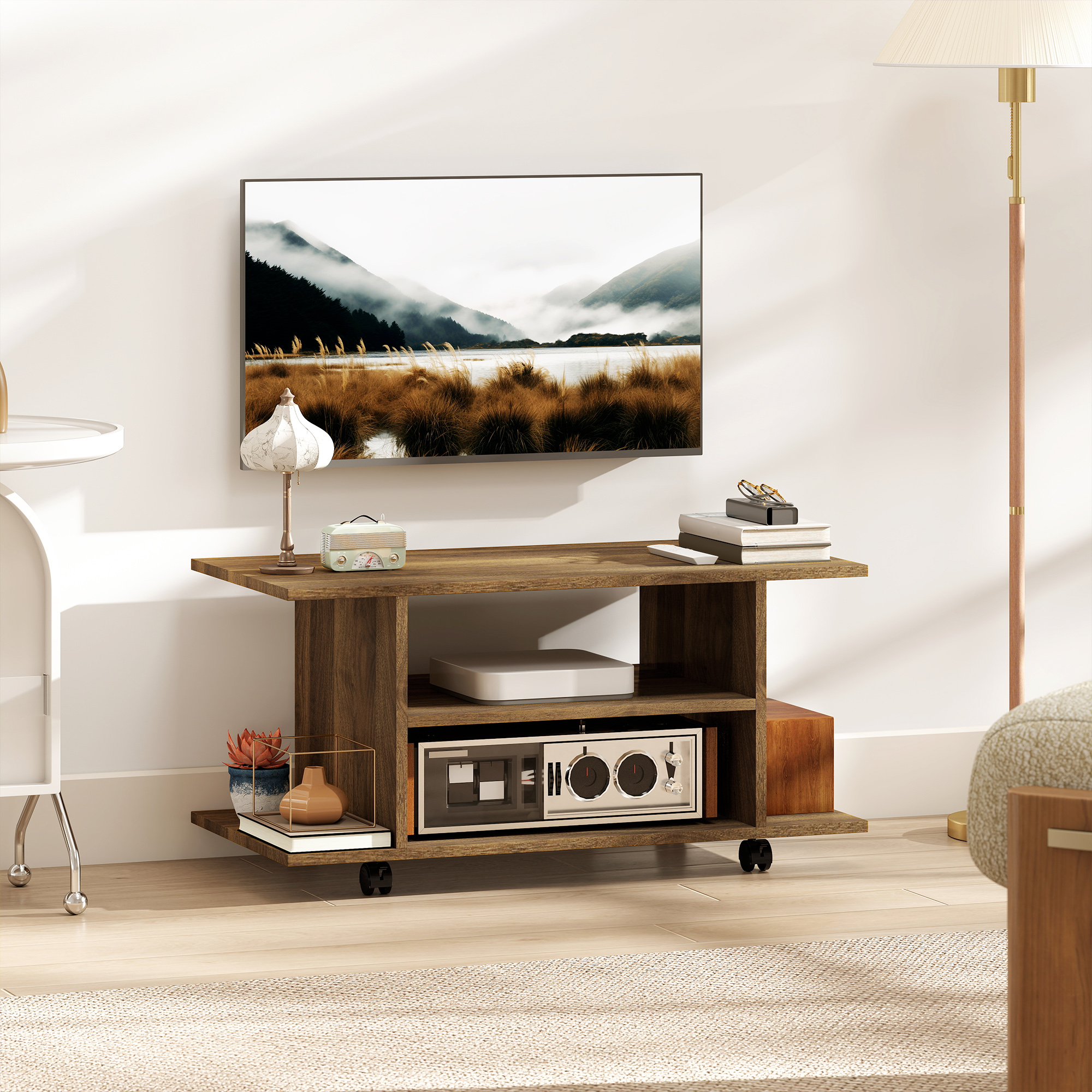 Mobile TV in legno con dispositivi e decorazioni, davanti a un TV con paesaggio.