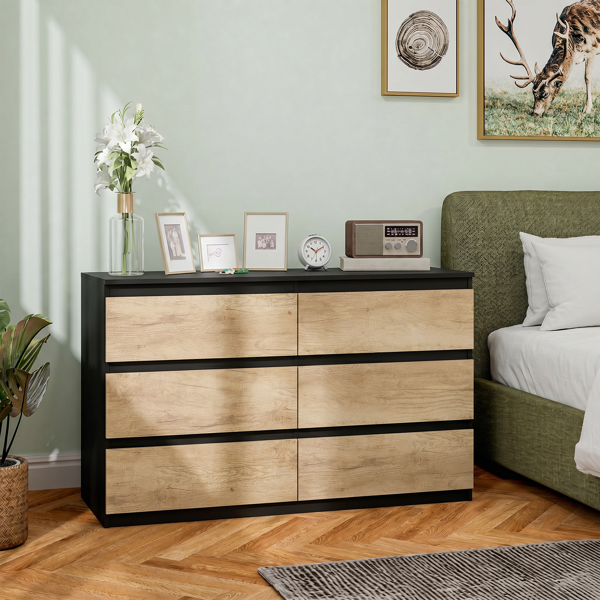 Una camera da letto con cassettiera, letto e quadri.