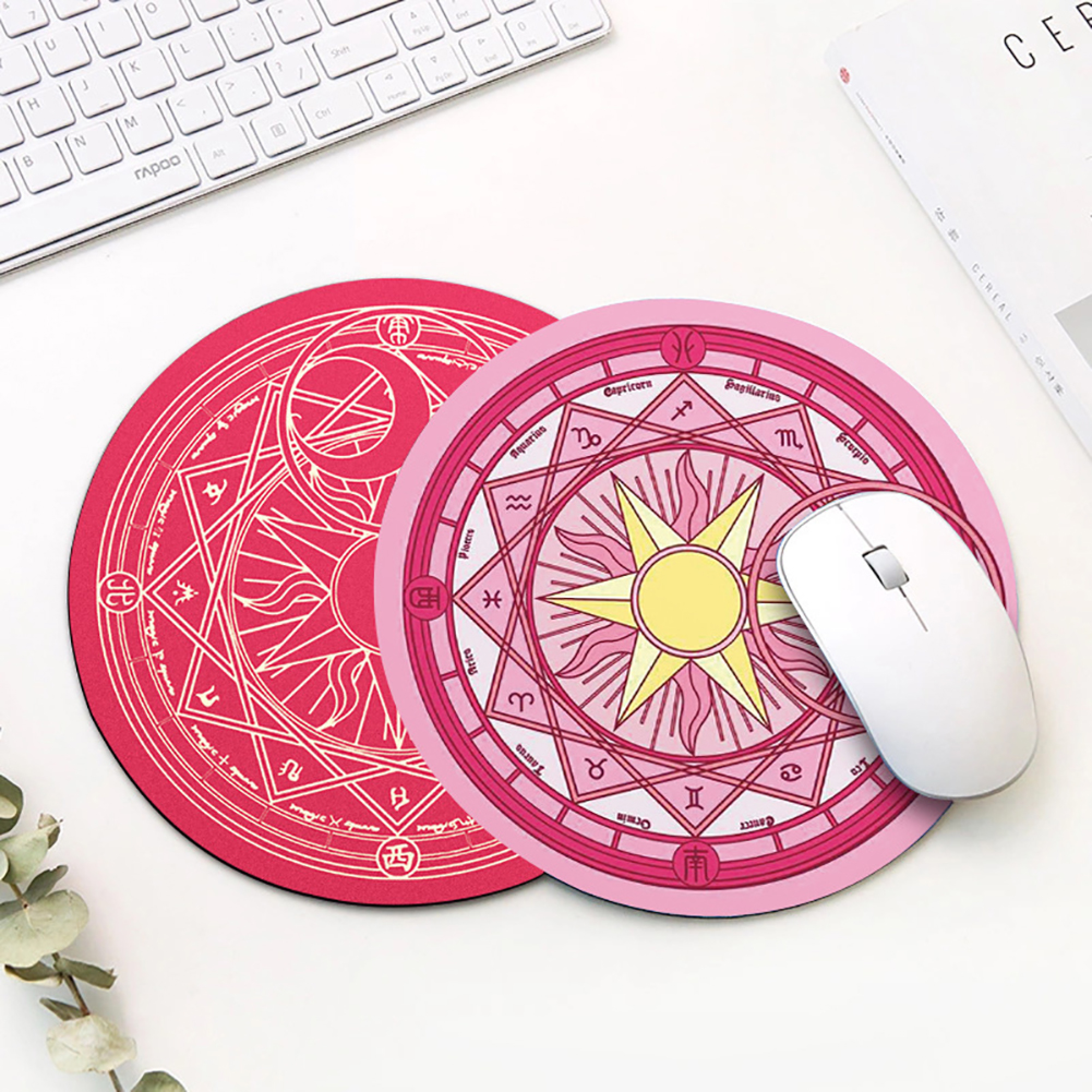 Zwei runde Mousepads mit astrologischen Symbolen liegen nebeneinander. Ein weißes Maus liegt auf dem rechten.