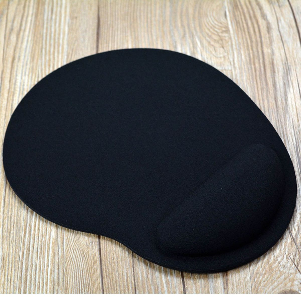 Schwarzes Mauspad mit Handgelenkauflage auf Holzhintergrund.