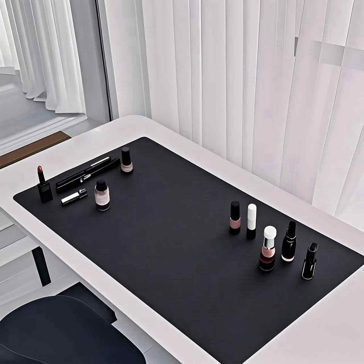 Ein Tisch mit einer schwarzen Matte, darauf sind Kosmetika wie Lippenstifte und Nagellacke platziert.