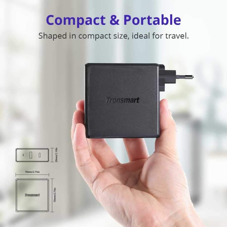 Bir el siyah bir Tronsmart adaptörü tutuyor. Boyutlar gösteriliyor.