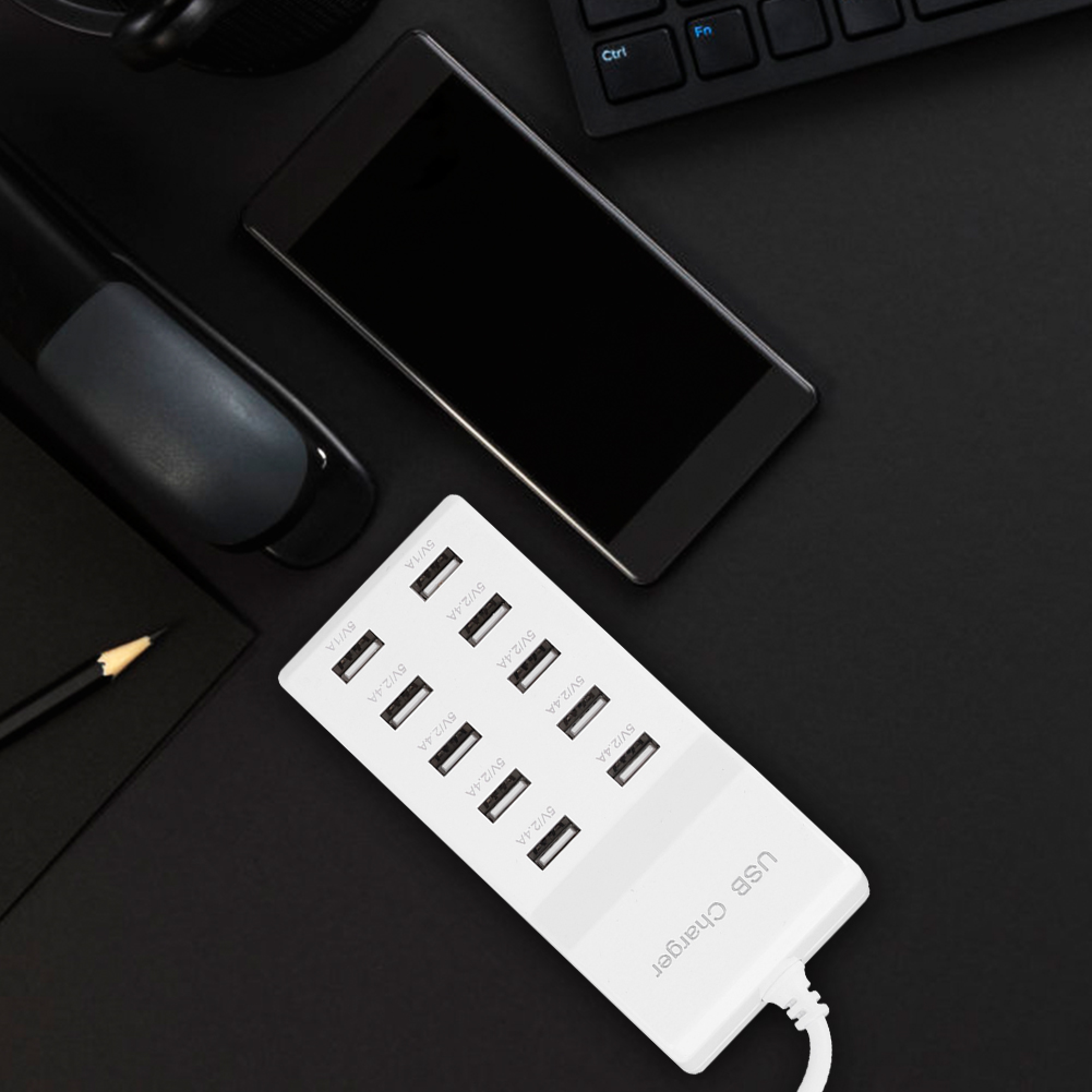 Ein weißes USB-Ladegerät mit mehreren Anschlüssen, einem Smartphone und einer Tastatur auf schwarzem Hintergrund.