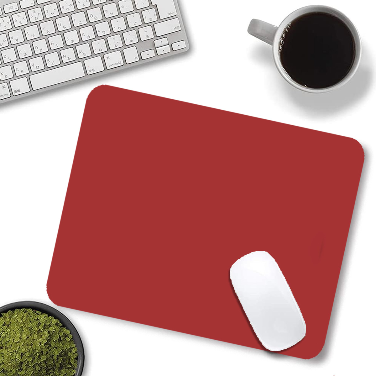 Rote Mausunterlage mit Tastatur, Kaffeetasse und Schüssel mit Granulat.