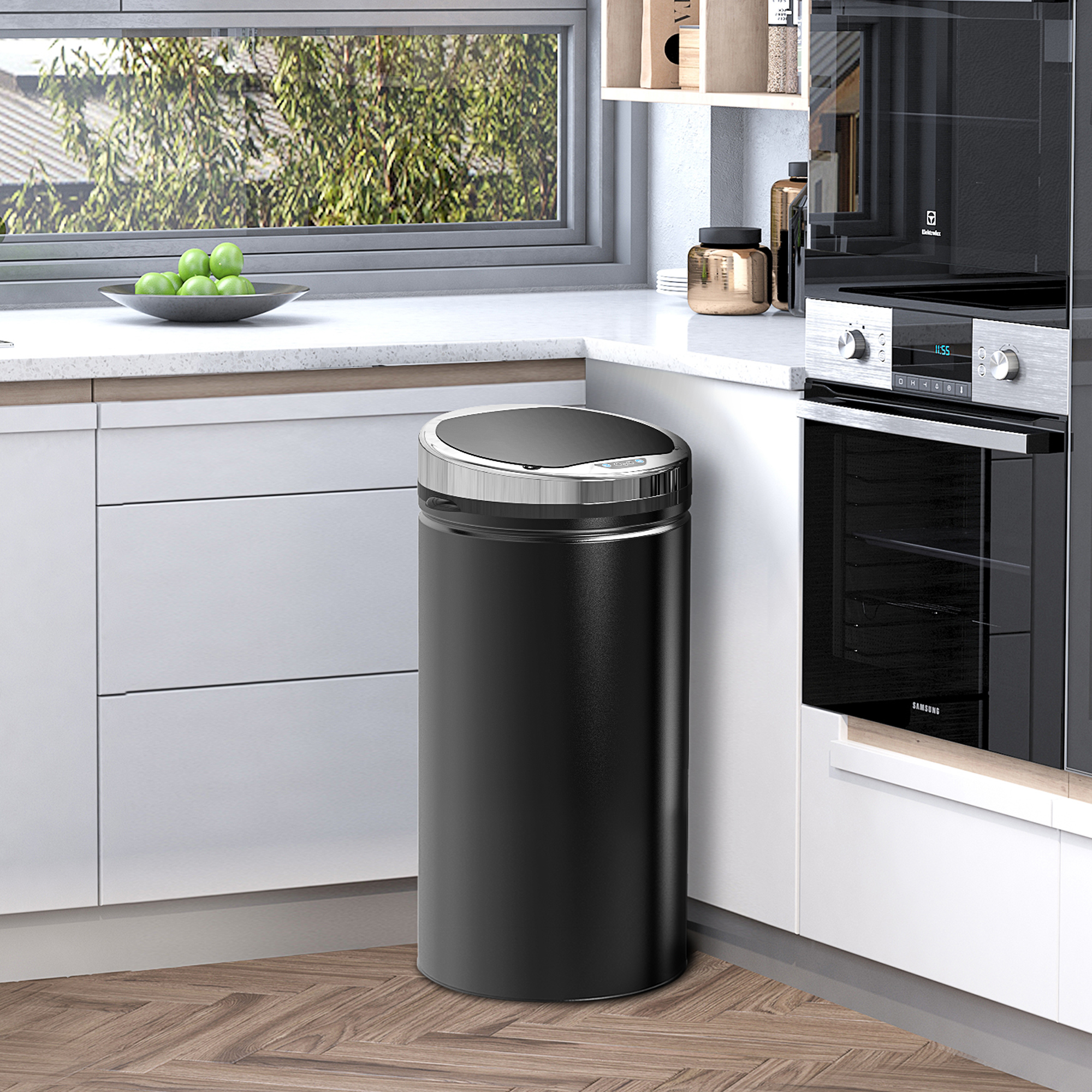 Moderno cestino nero accanto a un forno in una cucina con finestra.