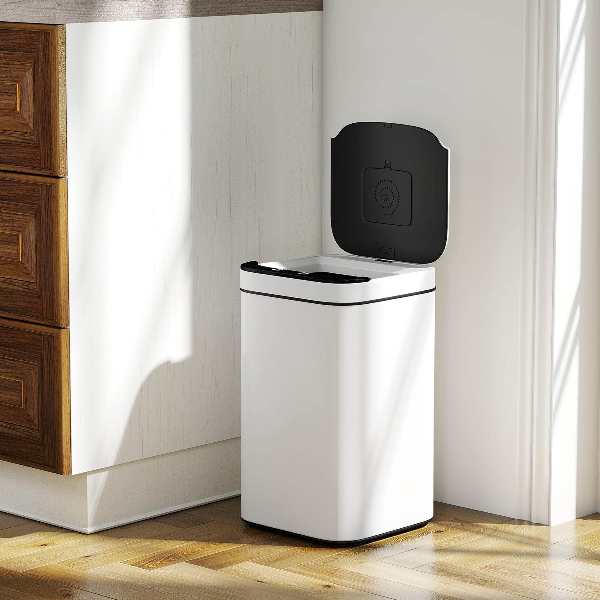 Un cestino bianco automatico con coperchio nero aperto, su pavimento in legno.