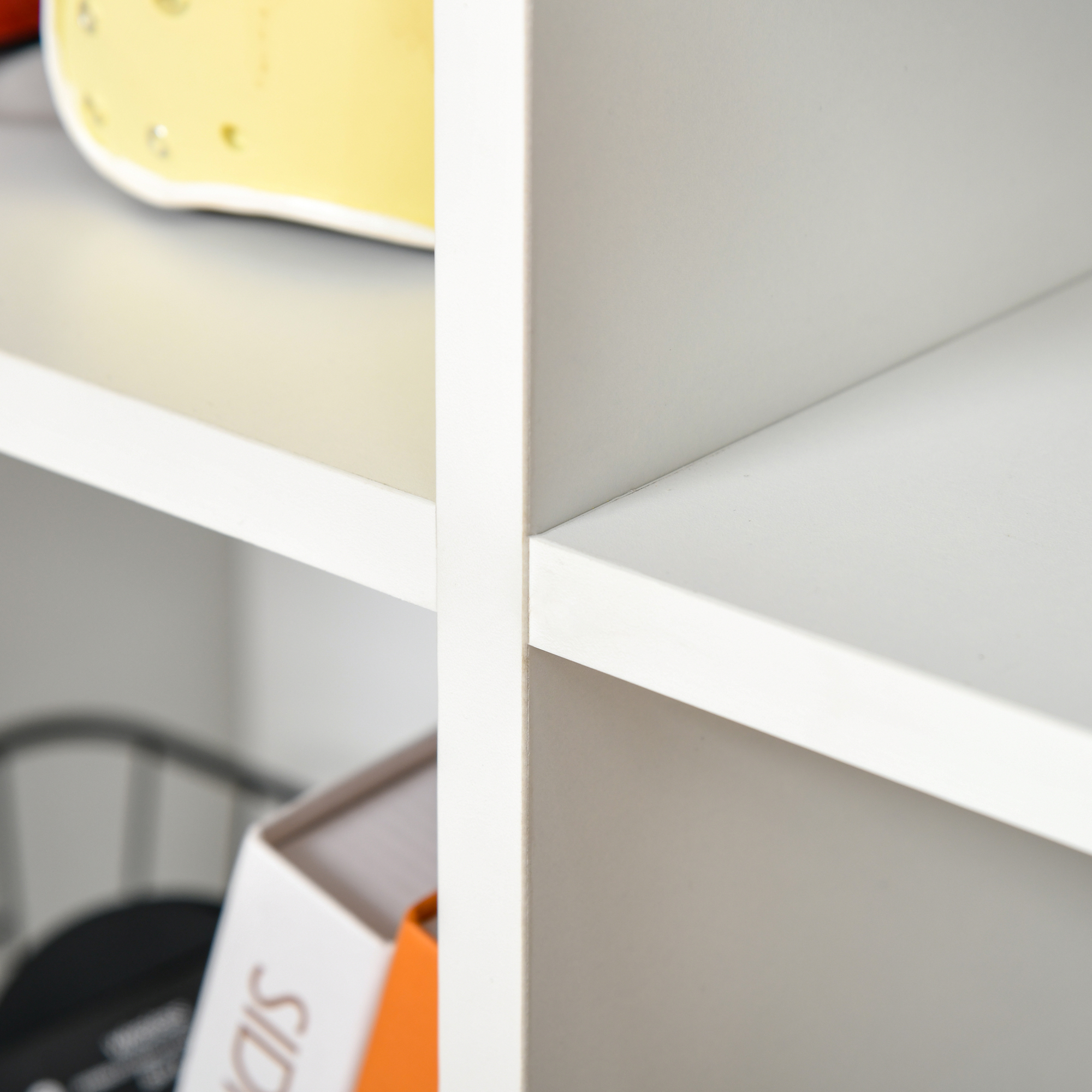 Un oggetto giallo su uno scaffale bianco accanto a libri.
