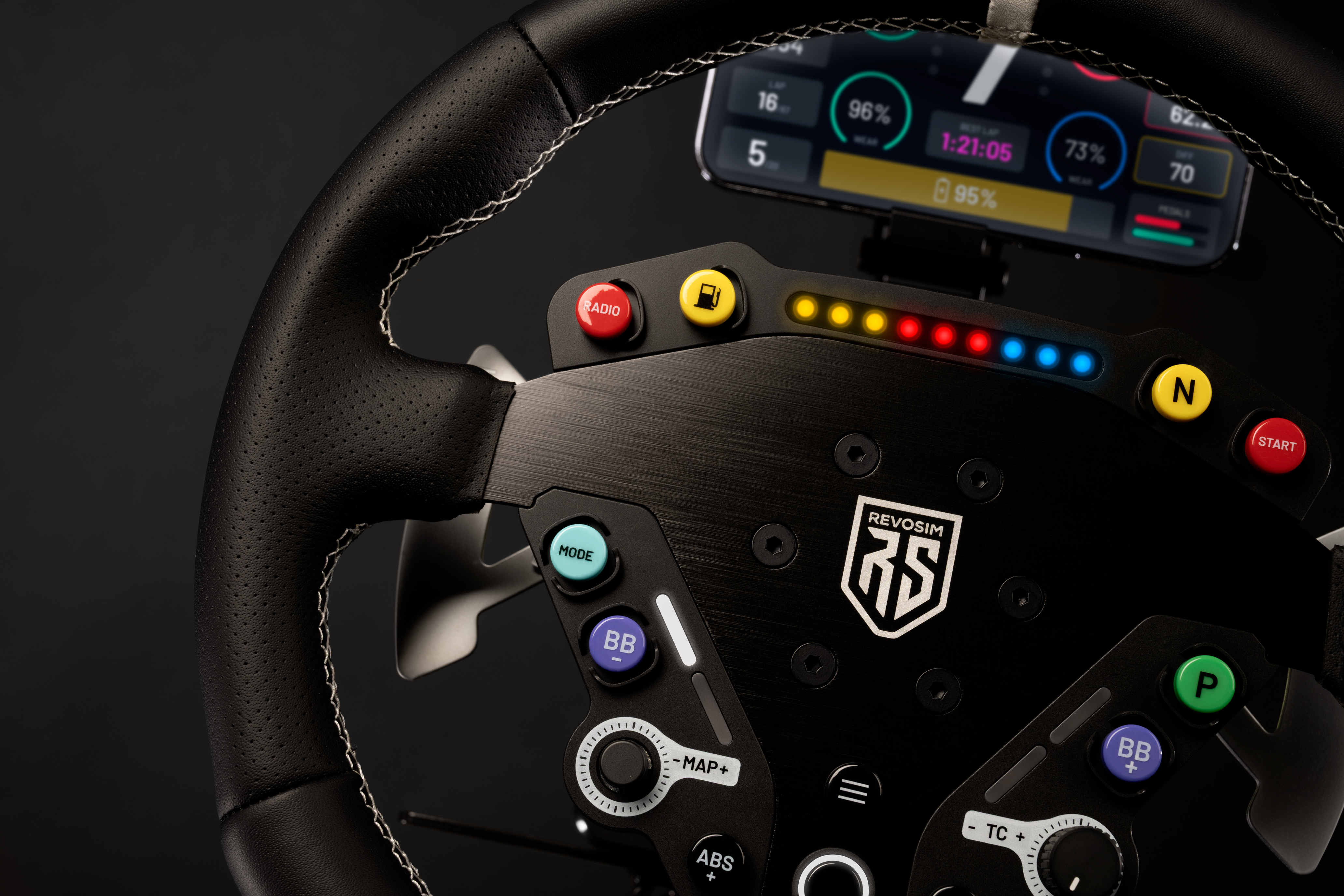 Primer plano de un volante de carreras negro con pantalla digital mostrando datos de carrera y botones coloridos.