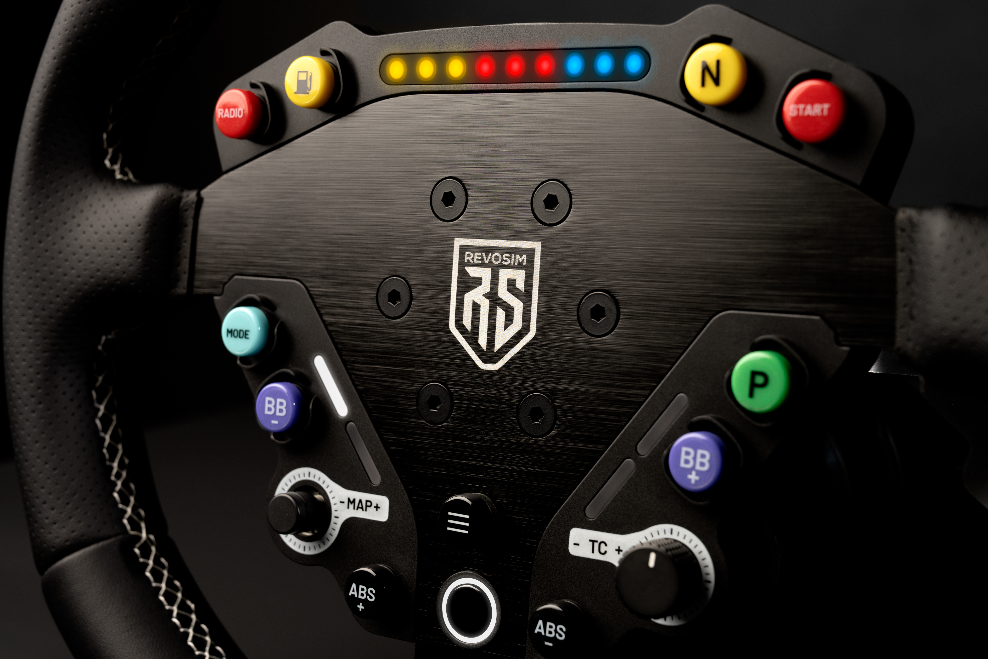 Un volante de carreras negro con muchos botones coloridos y LEDs.
