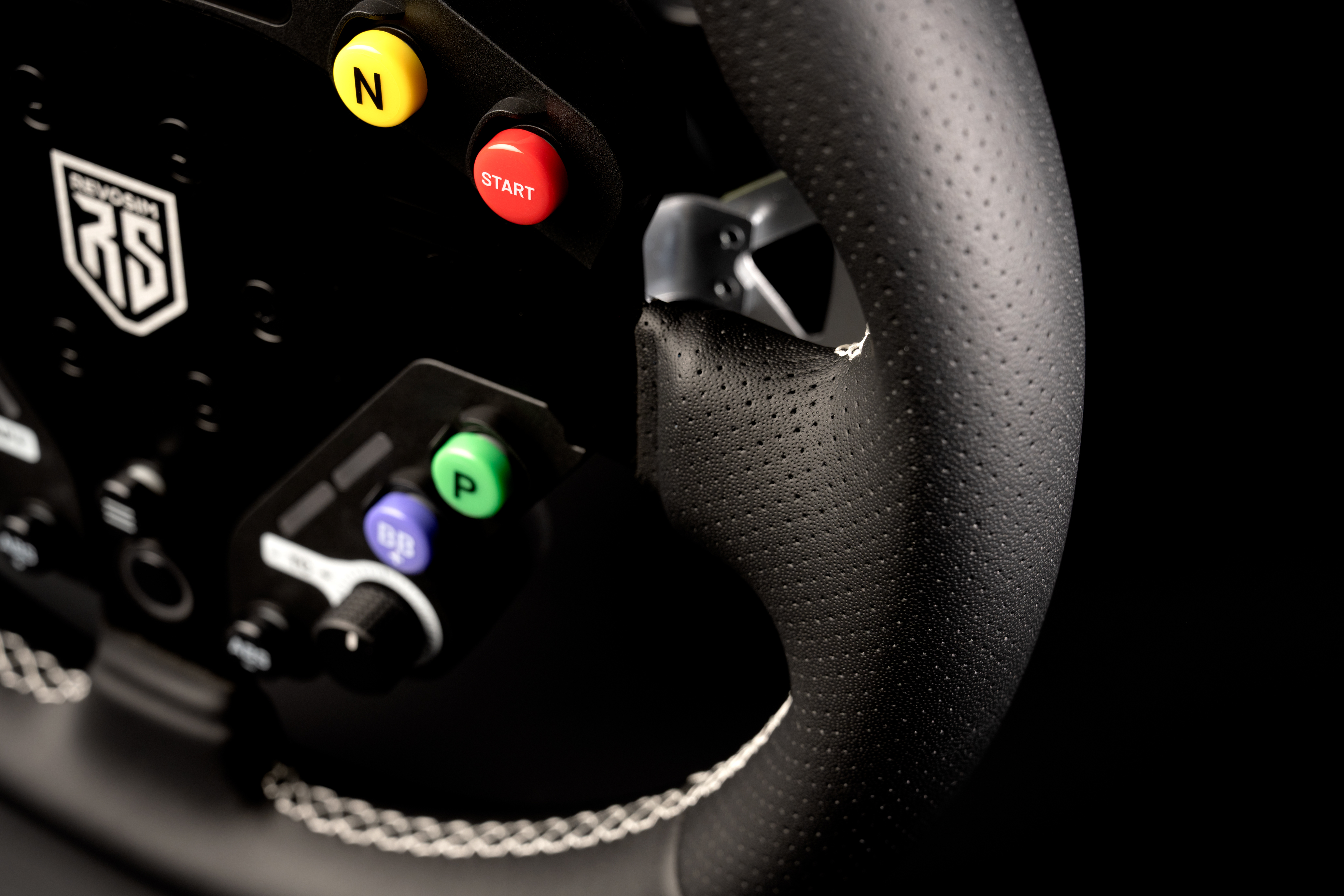 Primer plano de un volante de carreras negro con botones amarillos, rojos, verdes y morados.