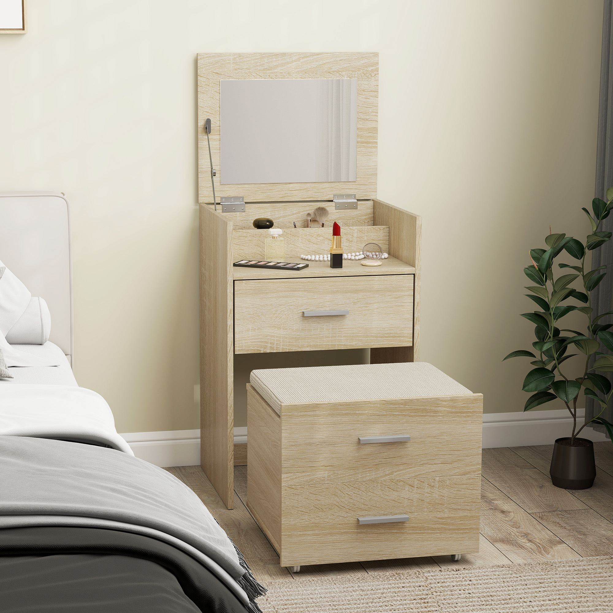 Toeletta in legno chiaro con specchio, cassetti e sgabello, accanto a un letto e una pianta.