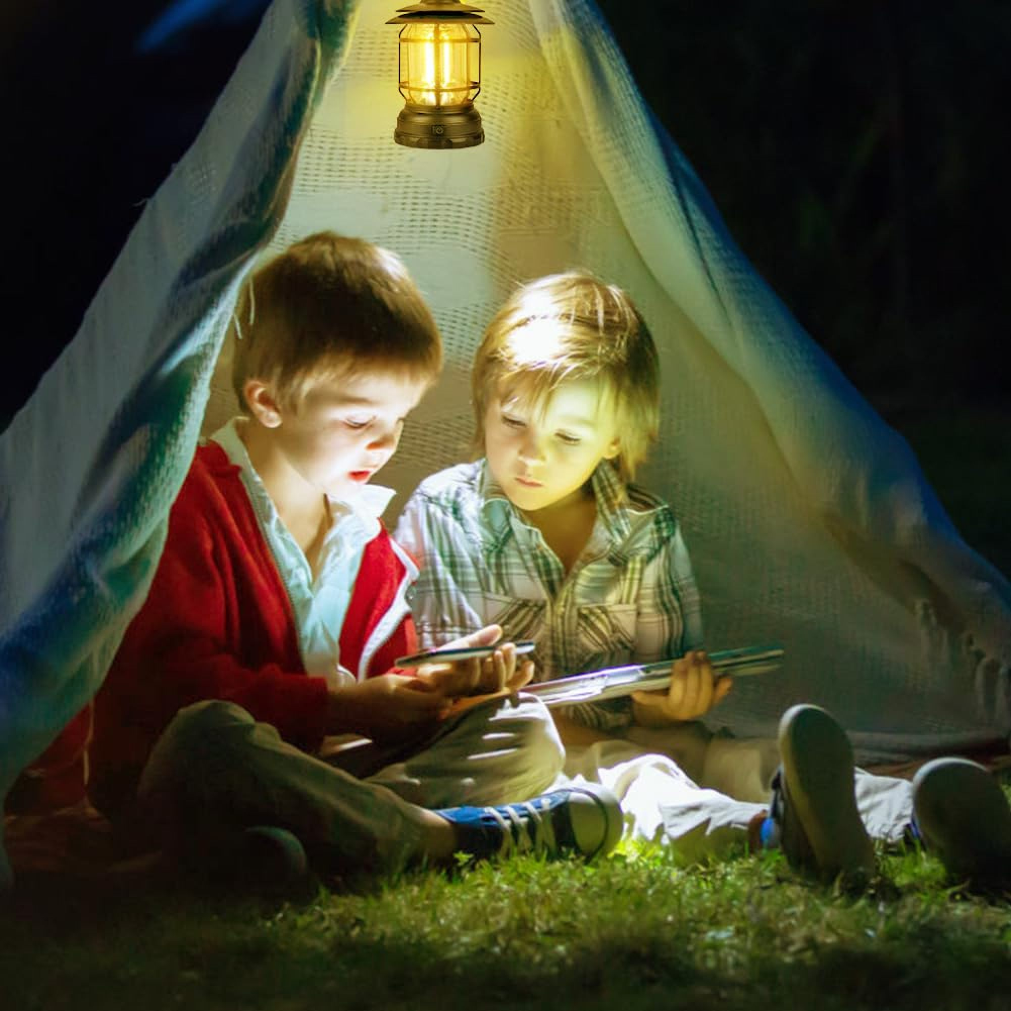Zwei Jungen lesen in einem Zelt bei Nacht, beleuchtet von einer Laterne.
