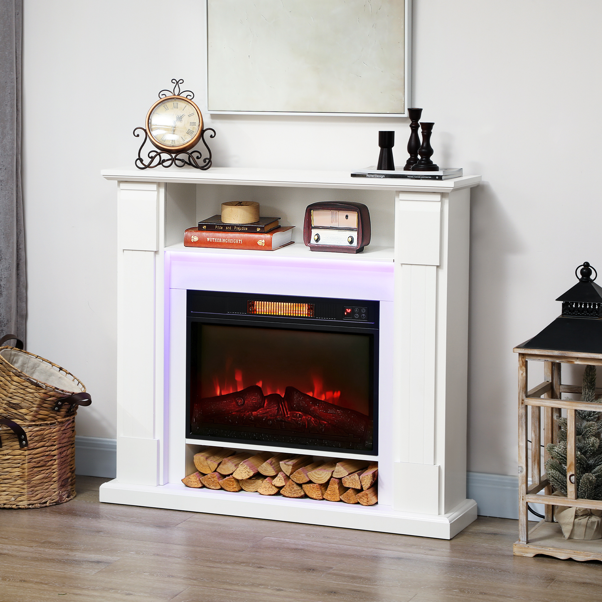 Un caminetto bianco con fuoco elettrico e legna. Decorato con orologio, radio e candelabri.