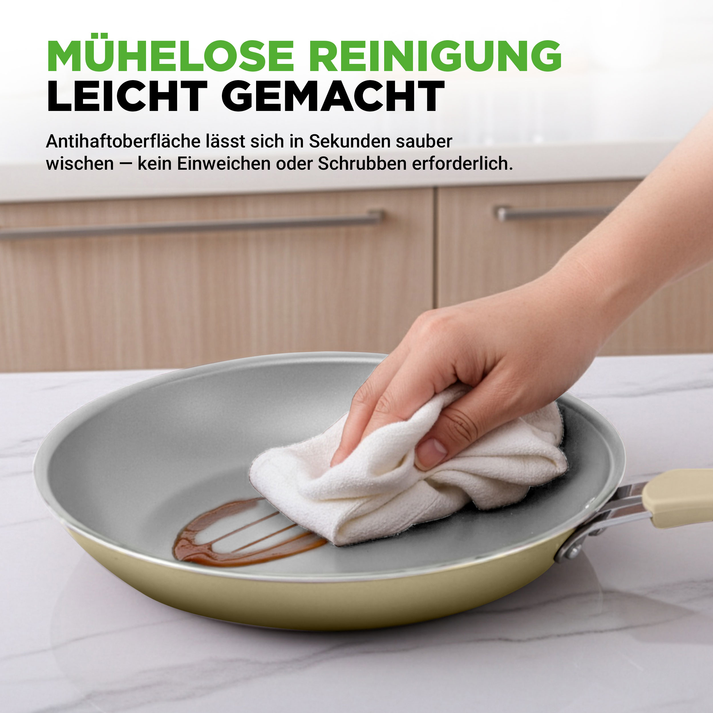 Hand wischt Pfanne mit weißem Tuch. Küchenschrank im Hintergrund.