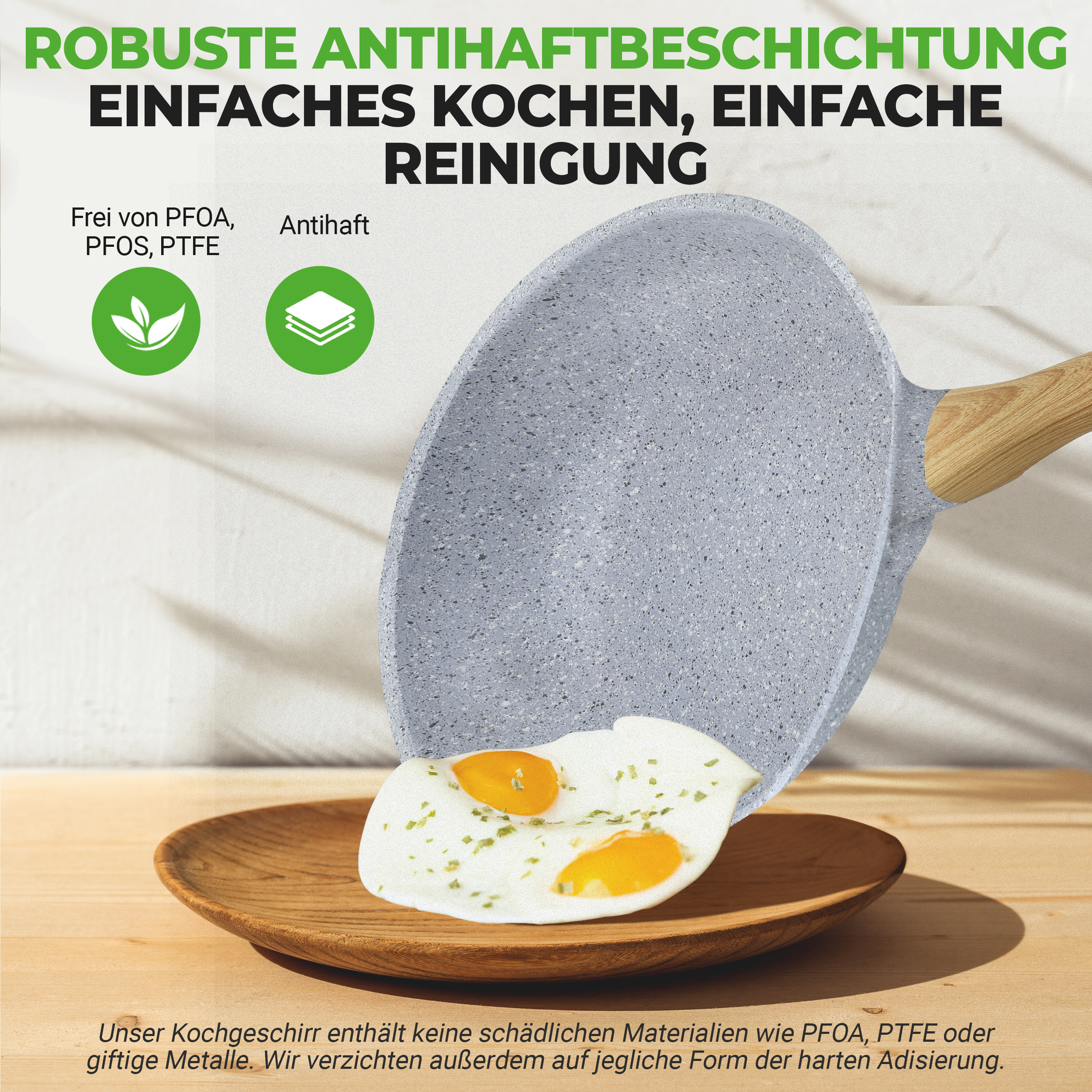 Graue Pfanne mit Holzgriff brät zwei Spiegeleier auf einem Holztablett.