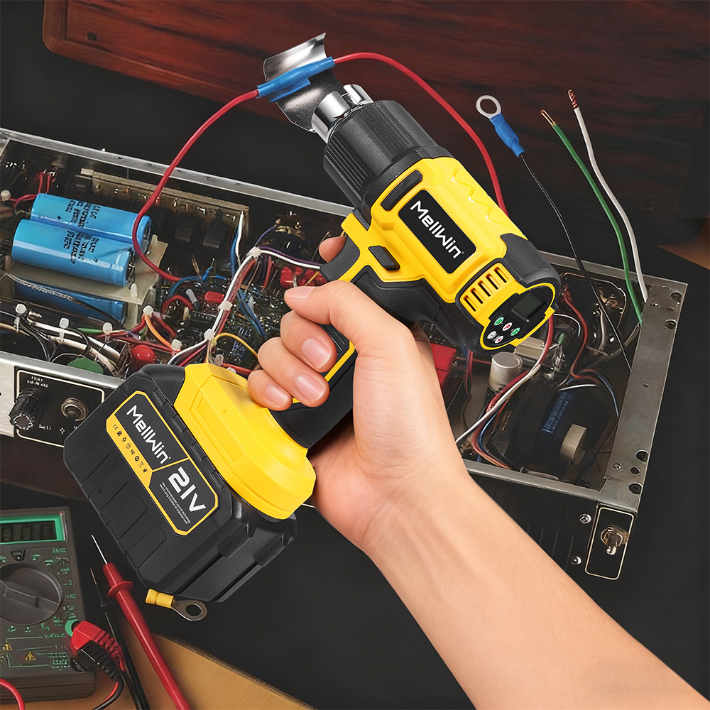 Gelber Heißluftföhn mit Akku in der Hand, der auf ein offenes elektronisches Gerät gerichtet ist.