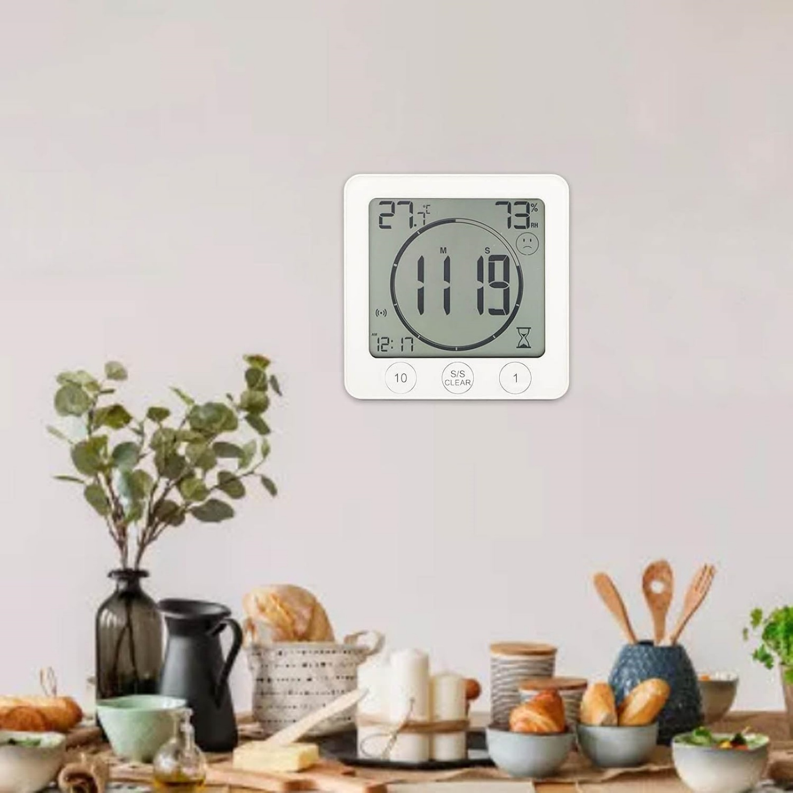Ein digitaler Thermometer/Hygrometer an einer Wand über einem Tisch mit Essen.