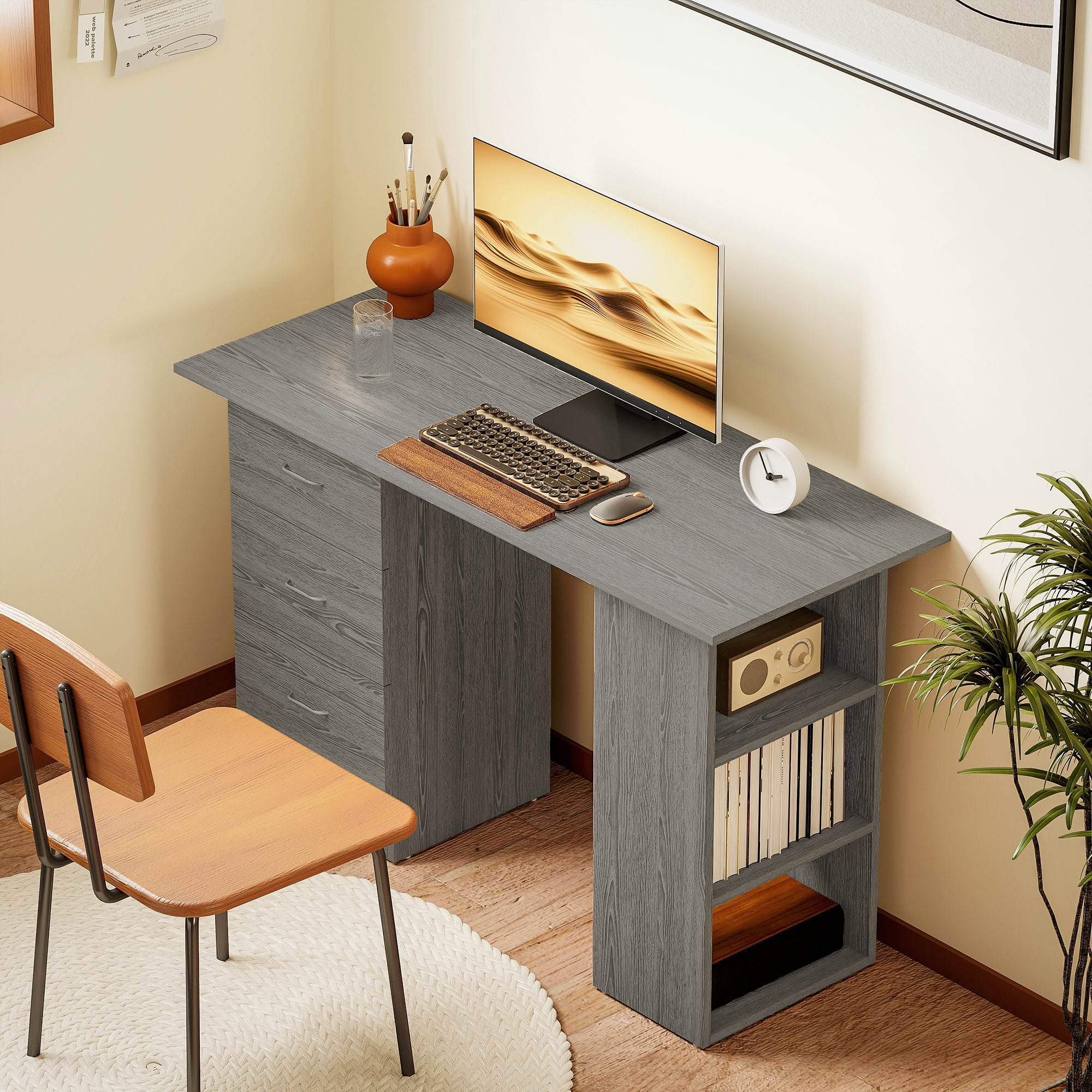 Una scrivania grigia con monitor, tastiera, mouse e sedia.