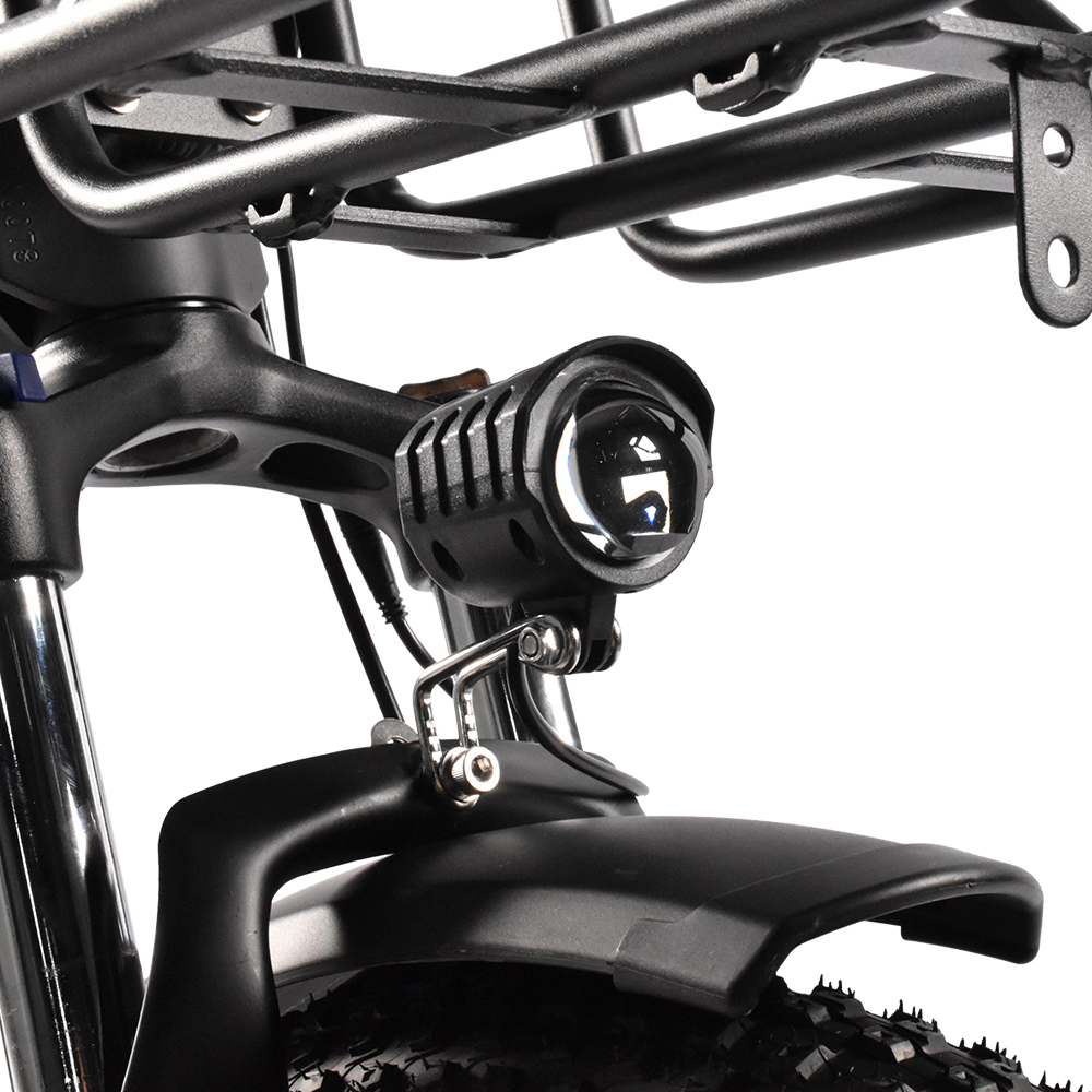 Un faro nero per bicicletta con alette e lente è montato sulla forcella.
