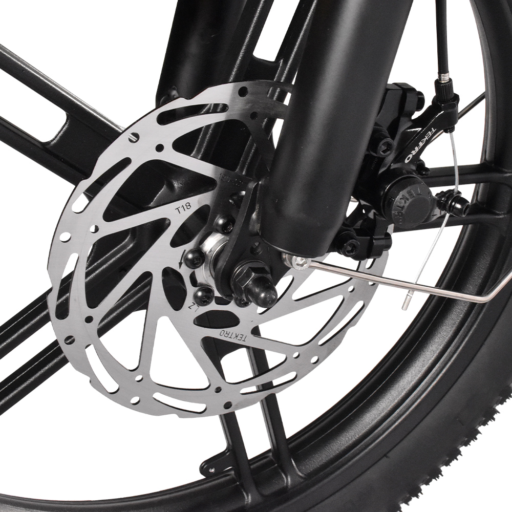 Nahaufnahme einer Fahrradscheibenbremse mit silberner Bremsscheibe und schwarzem Bremssattel.