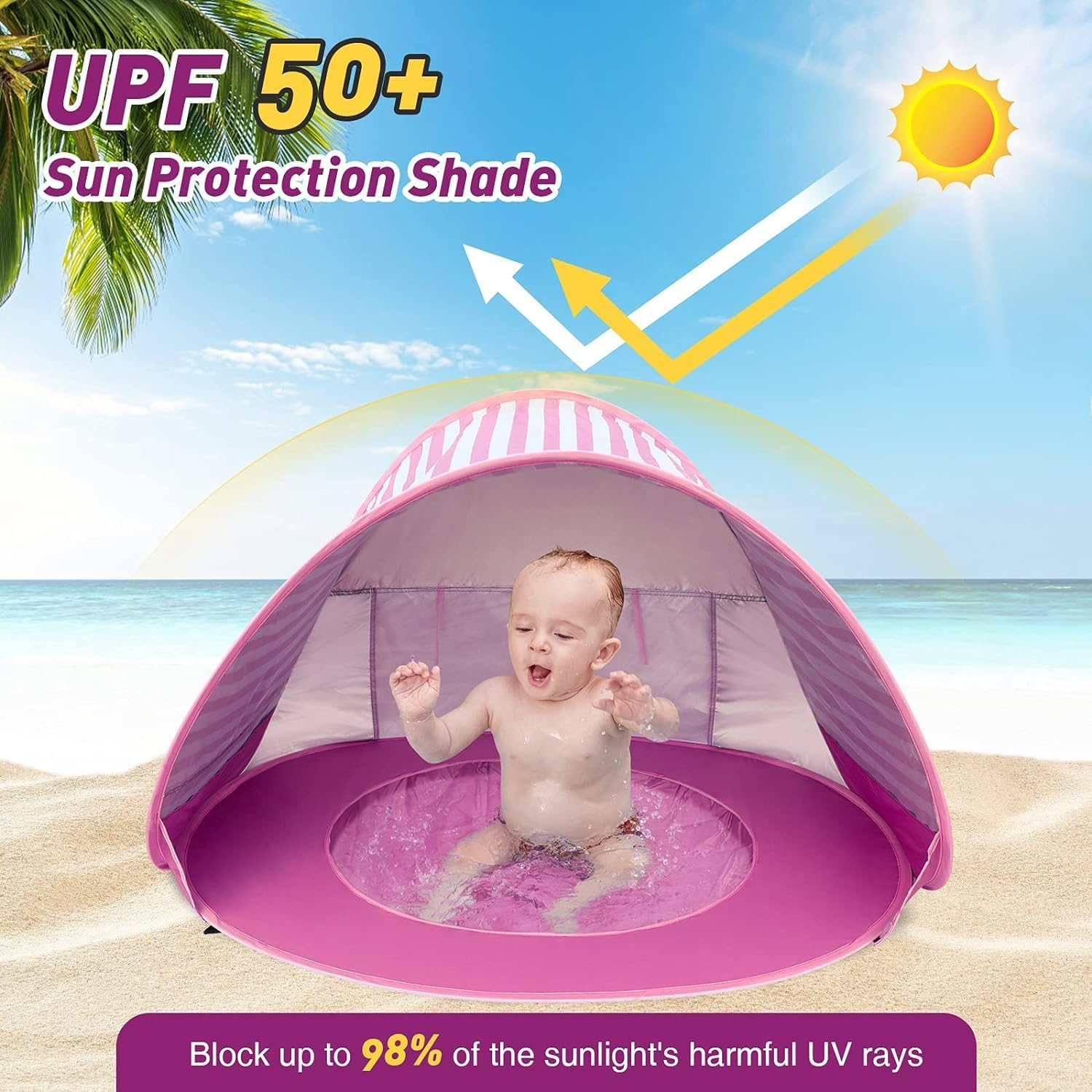 Ein Baby planscht in einem rosafarbenen Sonnenschirmzelt am Strand.