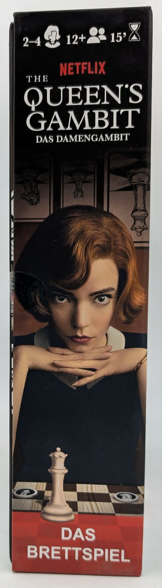 Die "Queen's Gambit" Brettspielbox zeigt Beth Harmon, eine Schachfigur und Spielinfos.