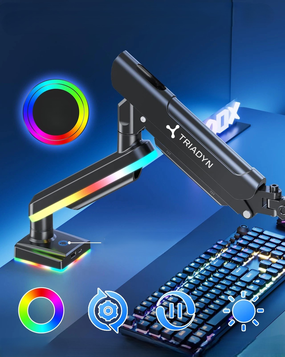 Czarny wysięgnik monitora z oświetleniem RGB obok podświetlanej klawiatury na niebieskim biurku.