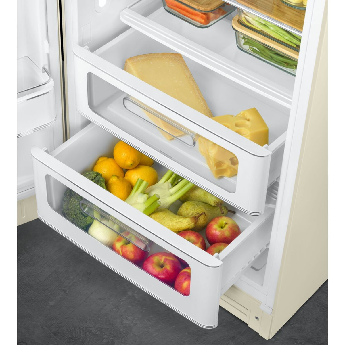 Ein offener Kühlschrank mit drei Schubladen, gefüllt mit Obst, Gemüse und Käse.