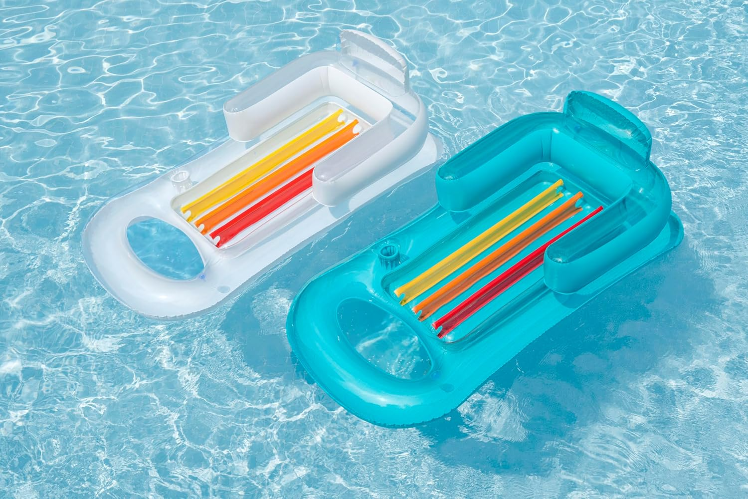 Zwei aufblasbare Schwimmtiere mit bunten Streifen auf blauem Wasser.