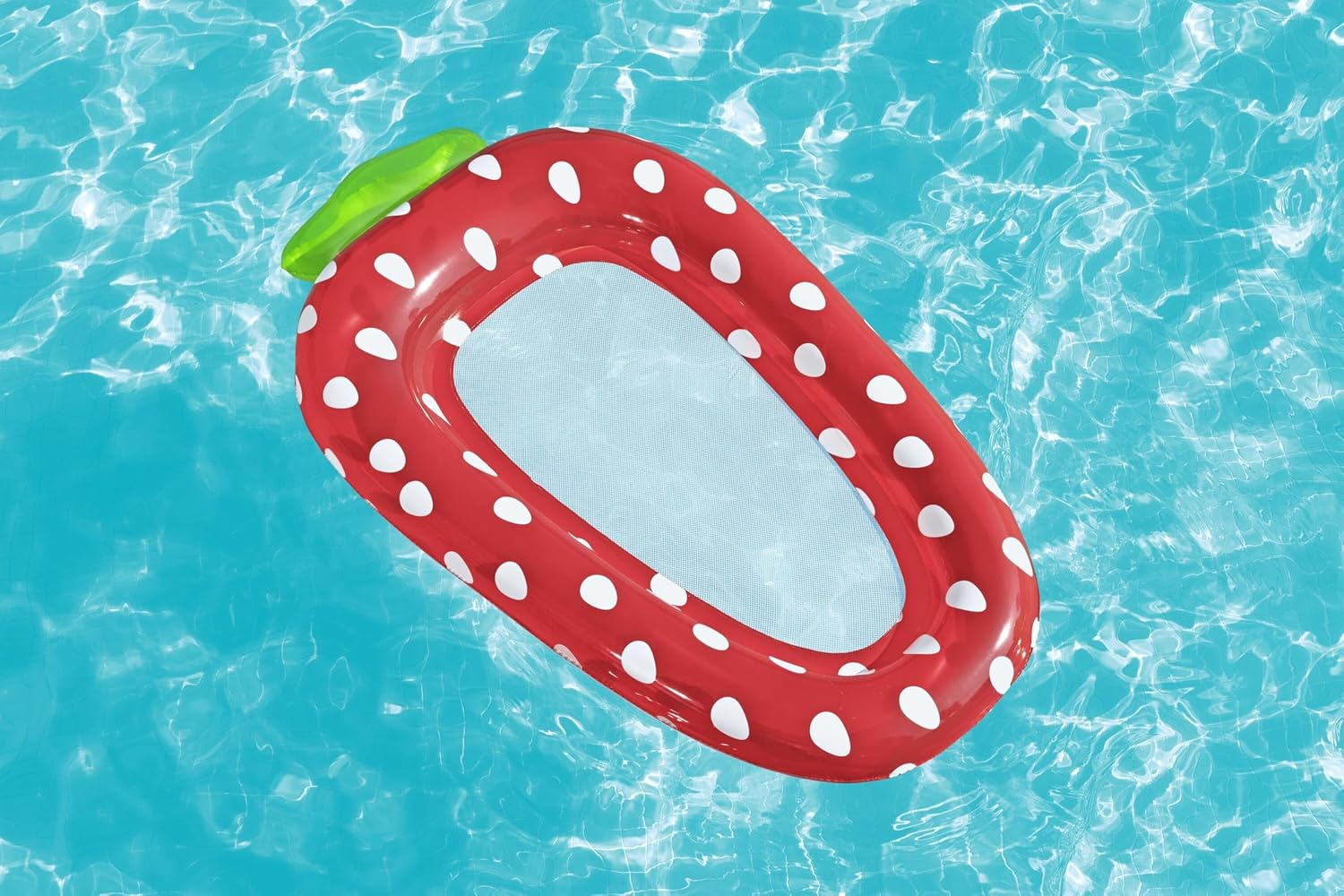 Ein roter aufblasbarer Schwimmring in Erdbeerform mit weißen Punkten schwimmt im Pool.