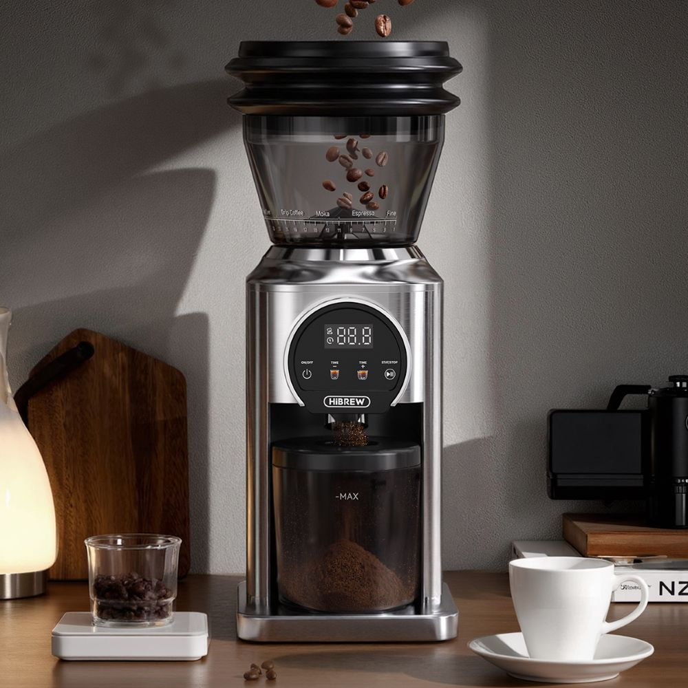 Un molinillo de café eléctrico plateado con granos cayendo en la tolva superior.