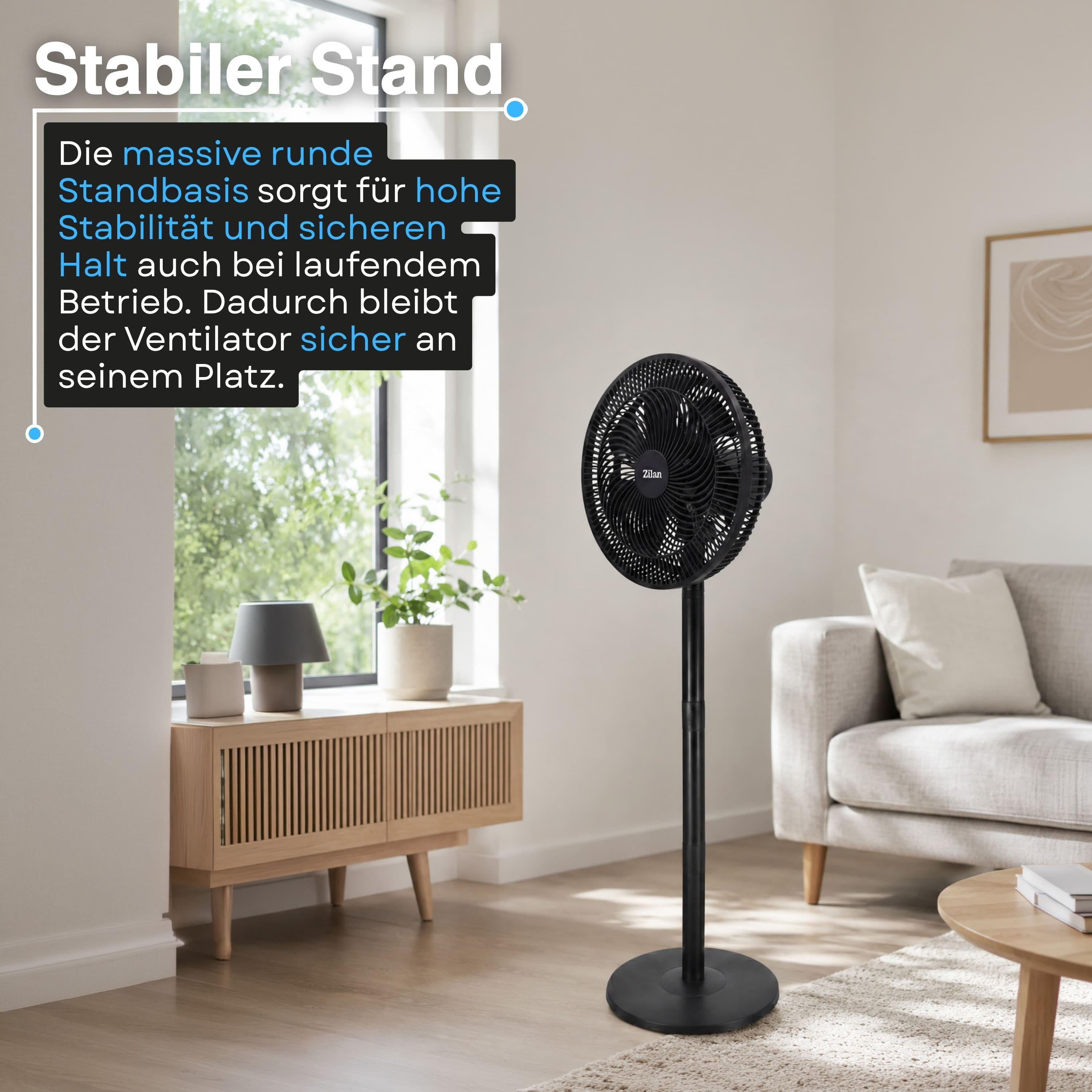 Ein schwarzer Standventilator steht auf einem Holzboden neben einem Sofa.