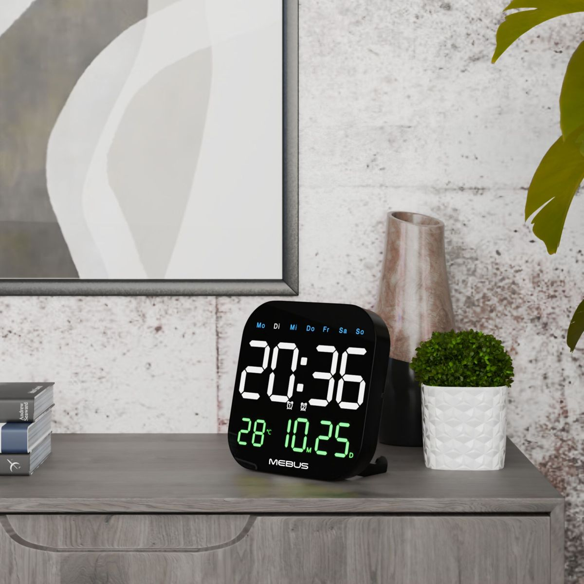 Ein schwarzer Digitalwecker zeigt 20:36 und 28°C 10.25. auf einem Nachttisch.