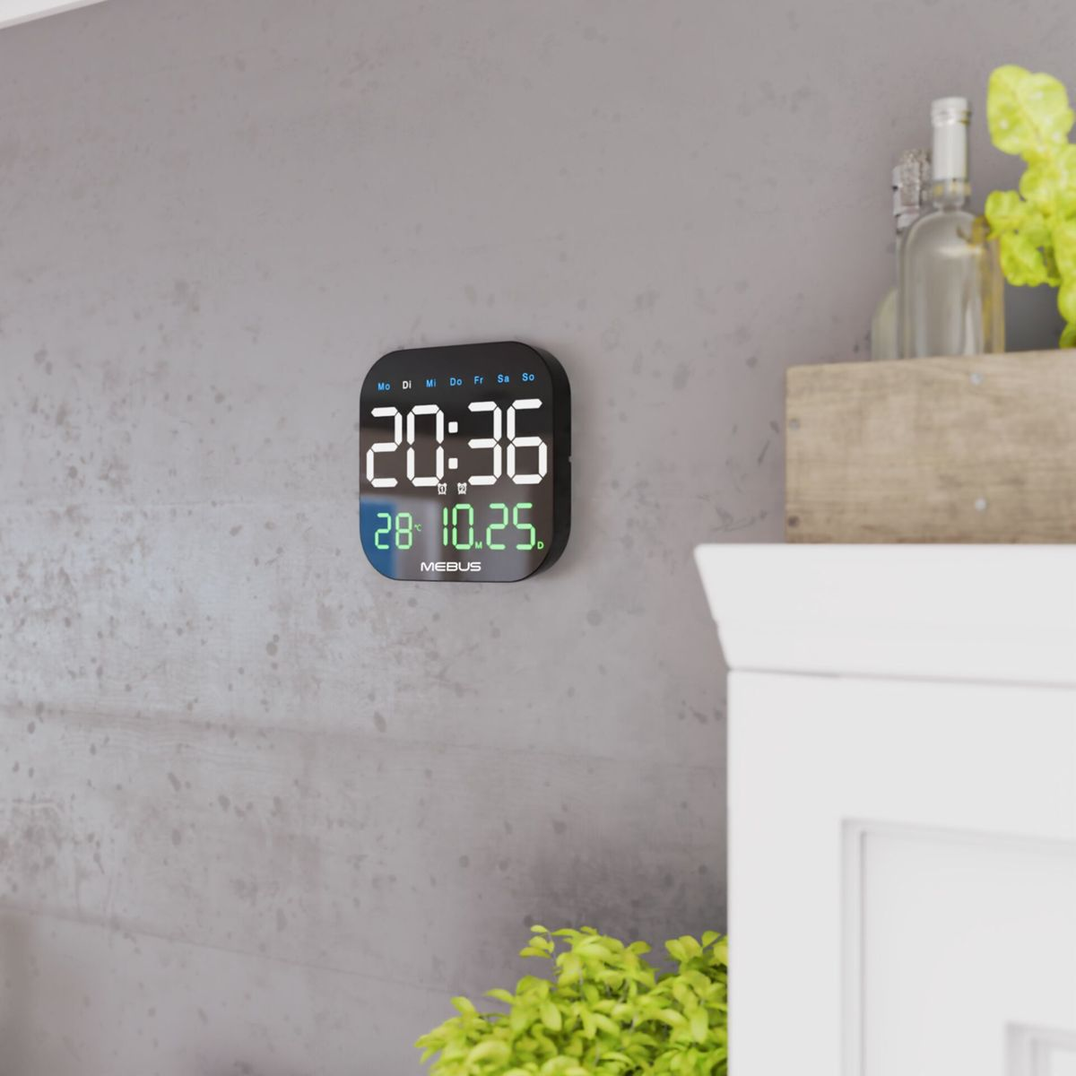 Digitaluhr zeigt 20:36 und 28.10.25 an. Hängt an einer Betonwand.